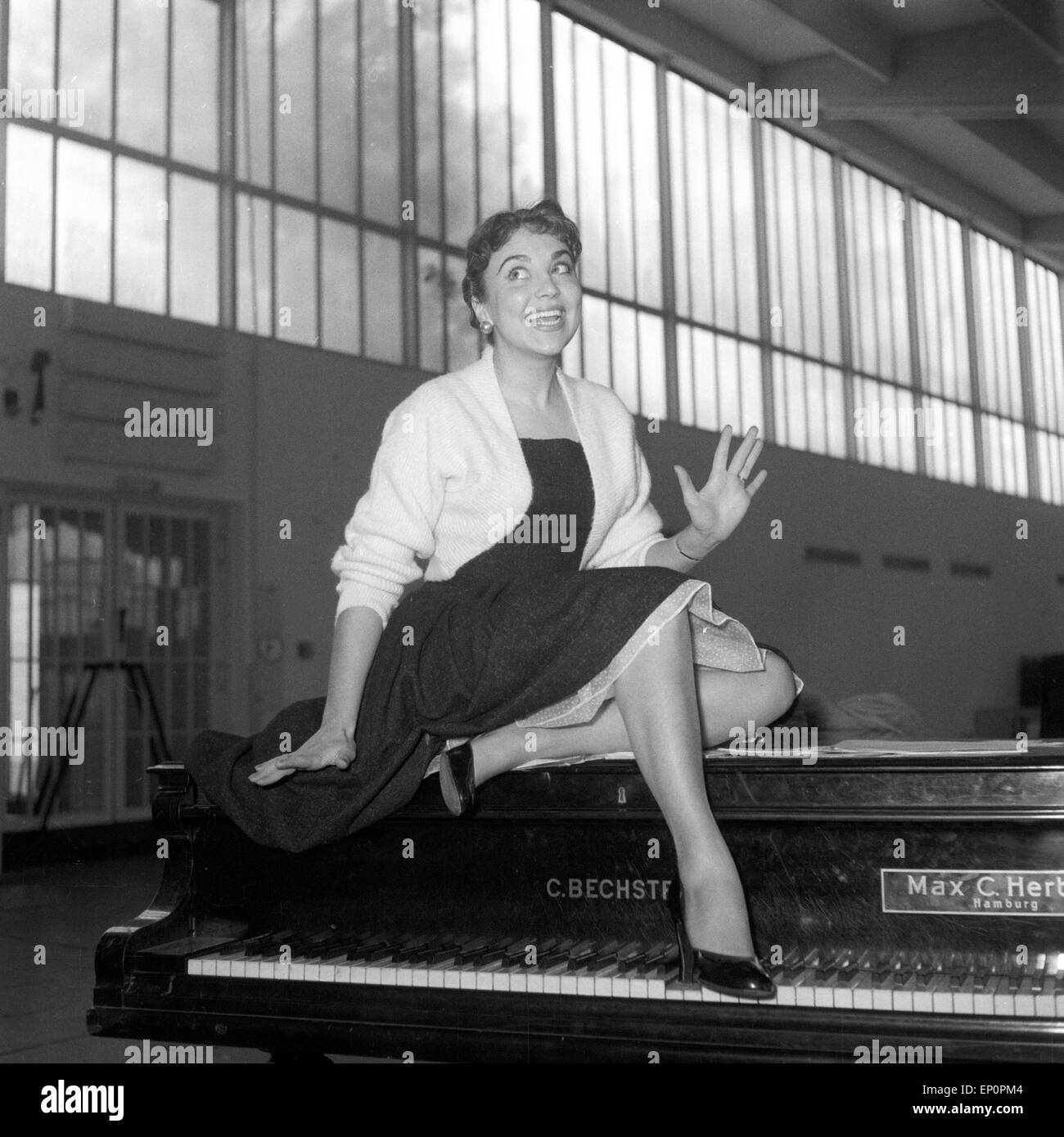 Deutsche Sängerin, Schauspielerin und Kabarettistin Rita Paul auf einem Flügel, Hambourg 1954. La chanteuse et actrice allemande, cab Banque D'Images