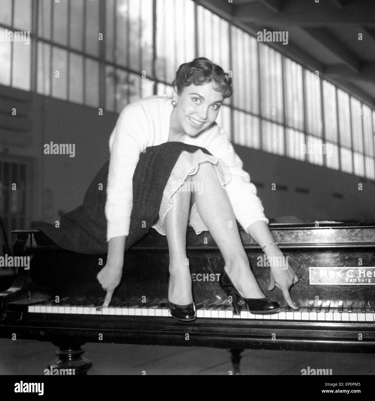 Deutsche Sängerin, Schauspielerin und Kabarettistin Rita Paul auf einem Flügel, Hambourg 1954. La chanteuse et actrice allemande, cab Banque D'Images