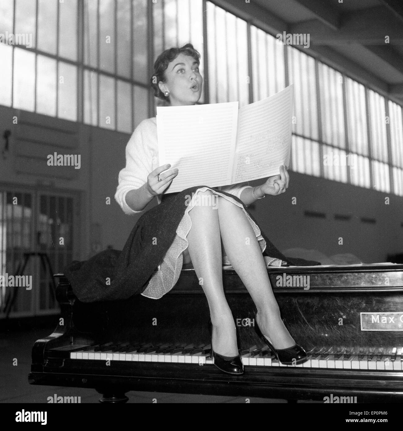 Deutsche Sängerin, Schauspielerin und Kabarettistin Rita Paul auf einem Flügel, Hambourg 1954. La chanteuse et actrice allemande, cab Banque D'Images