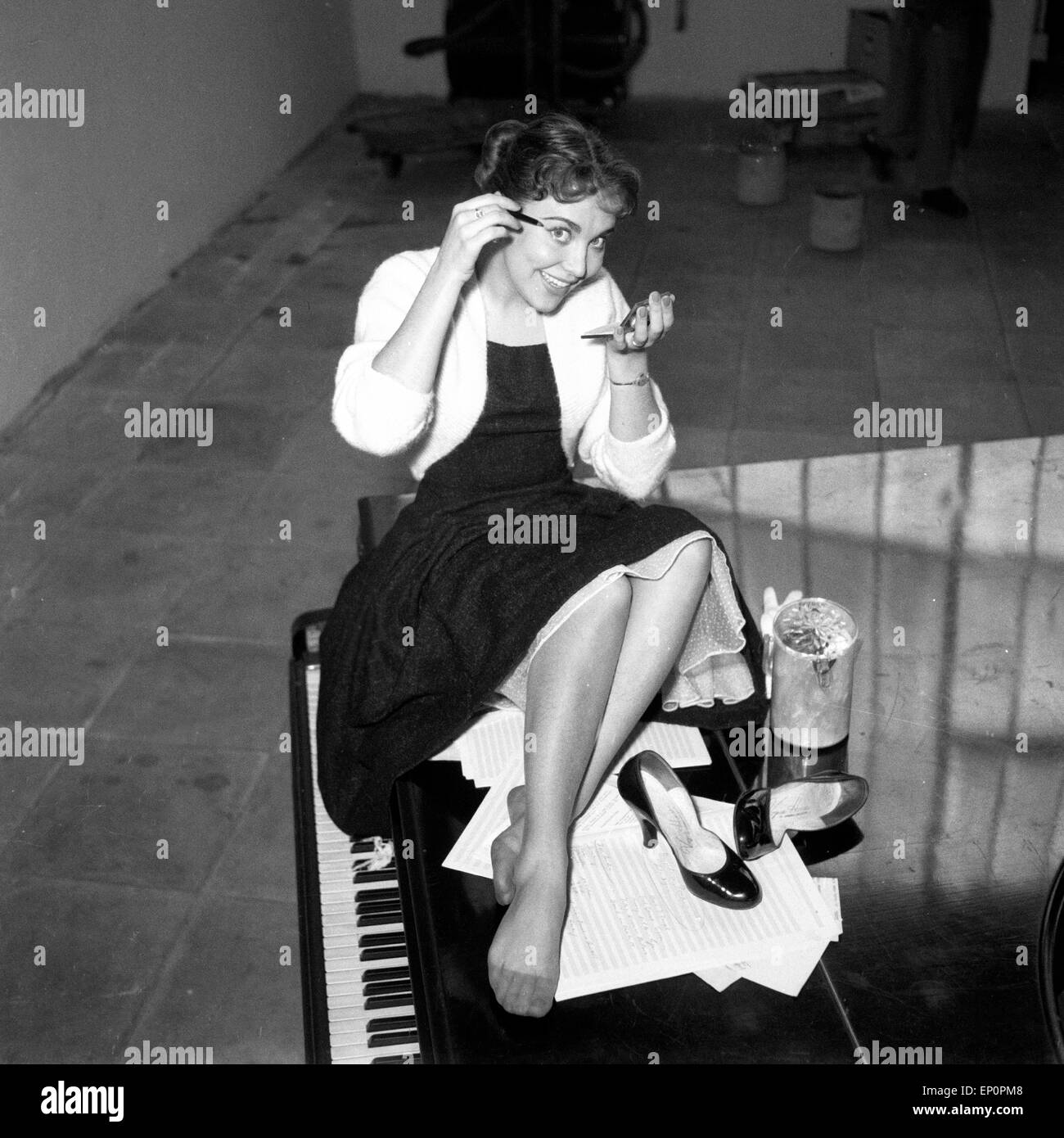 Deutsche Sängerin, Schauspielerin und Kabarettistin Rita Paul auf einem Flügel, Hambourg 1954. La chanteuse et actrice allemande, cab Banque D'Images