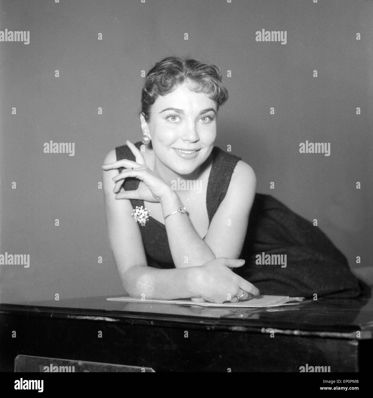 Deutsche Sängerin, Schauspielerin und Kabarettistin Rita Paul räkelt sich auf einem Flügel, Hambourg 1954. L'actrice allemande, tr Banque D'Images