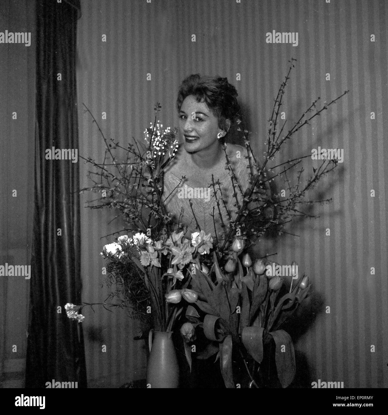 Deutsche Sängerin, Schauspielerin und Tänzerin hinter Evelyn Künneke, Blumensträußen Deutschland 1956. L'actrice allemande, singe Banque D'Images