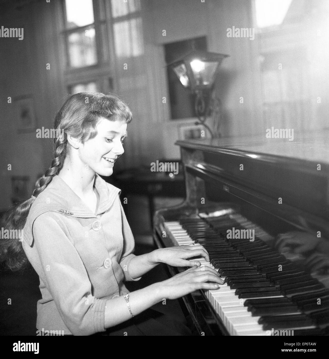 Ein Mädchen spielt une einem Flügel, Hambourg 1956. Une petite fille jouant un grand piano. Banque D'Images