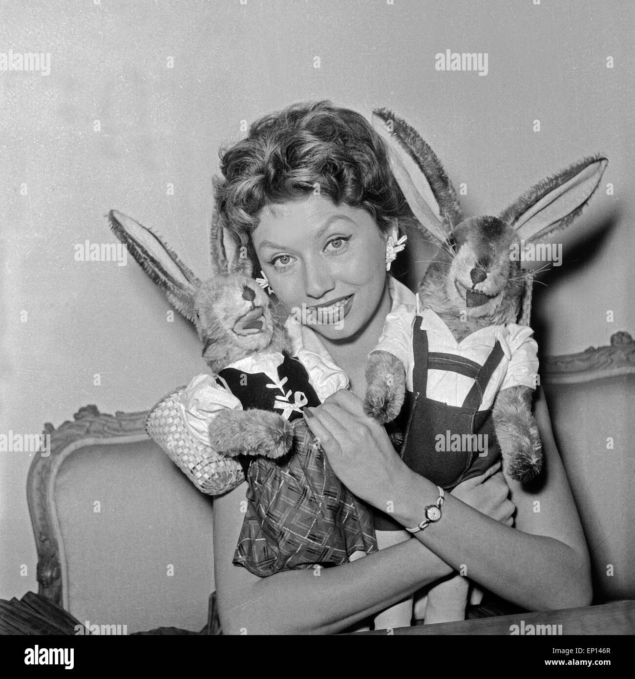 Deutsche Schauspielerin Gisela Lelim Michel mit zwei Osterhasen, Deutschland 1950er Jahre. L'actrice allemande Gisela Lelim Michel avec deux Banque D'Images