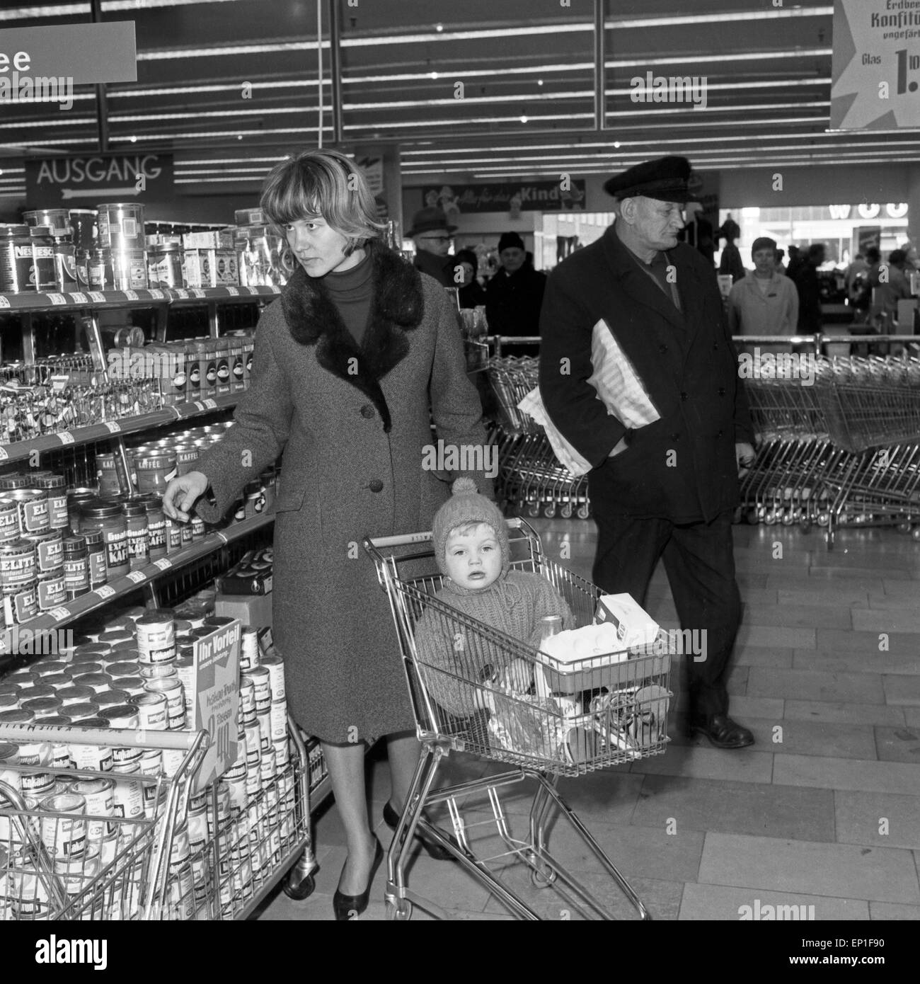 Eine Kundin, genre im Einkaufswagen auf ihrem Gang durch einen Dach Photovoltaik à Hamburg, Deutschland, Anfang 1960 er Jahre. Banque D'Images