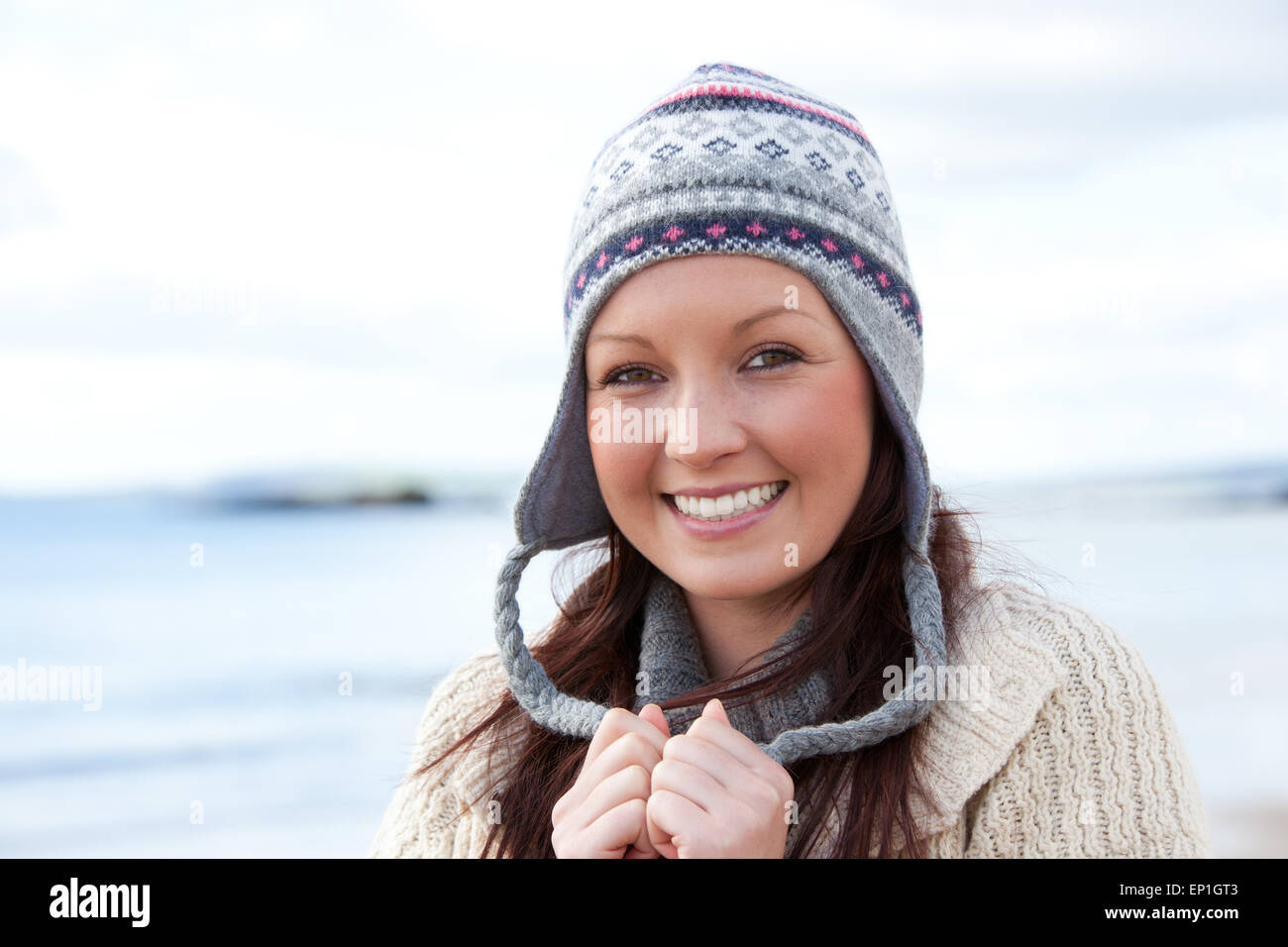 Smilng wearnig jeune femme chapeau sur fond de mer Banque D'Images