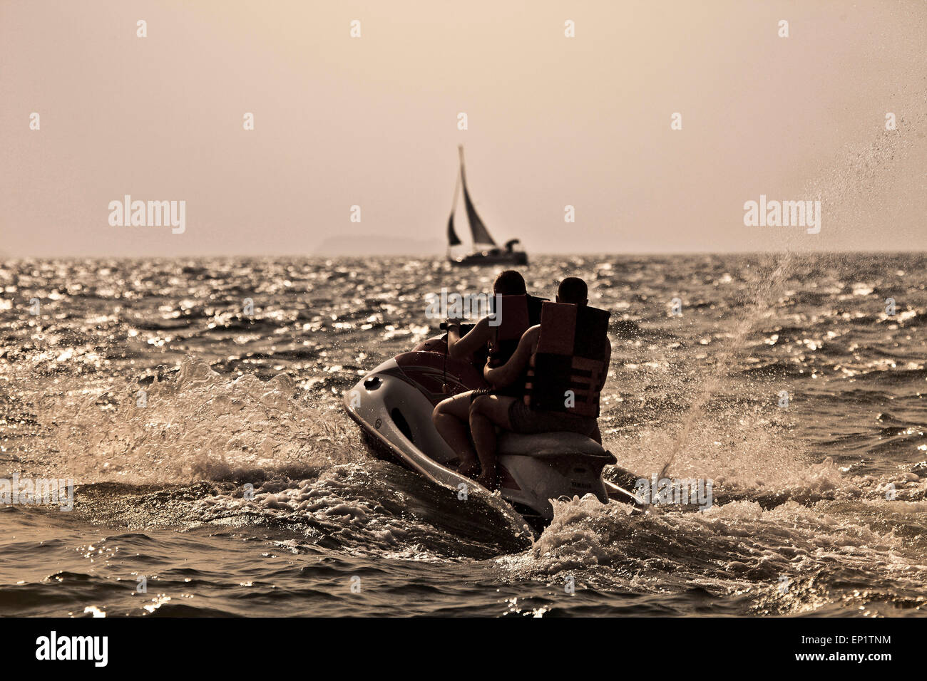 Vitesse de touristes au loin dans la baie de Bangkok sur un jet ski -powered by Banque D'Images