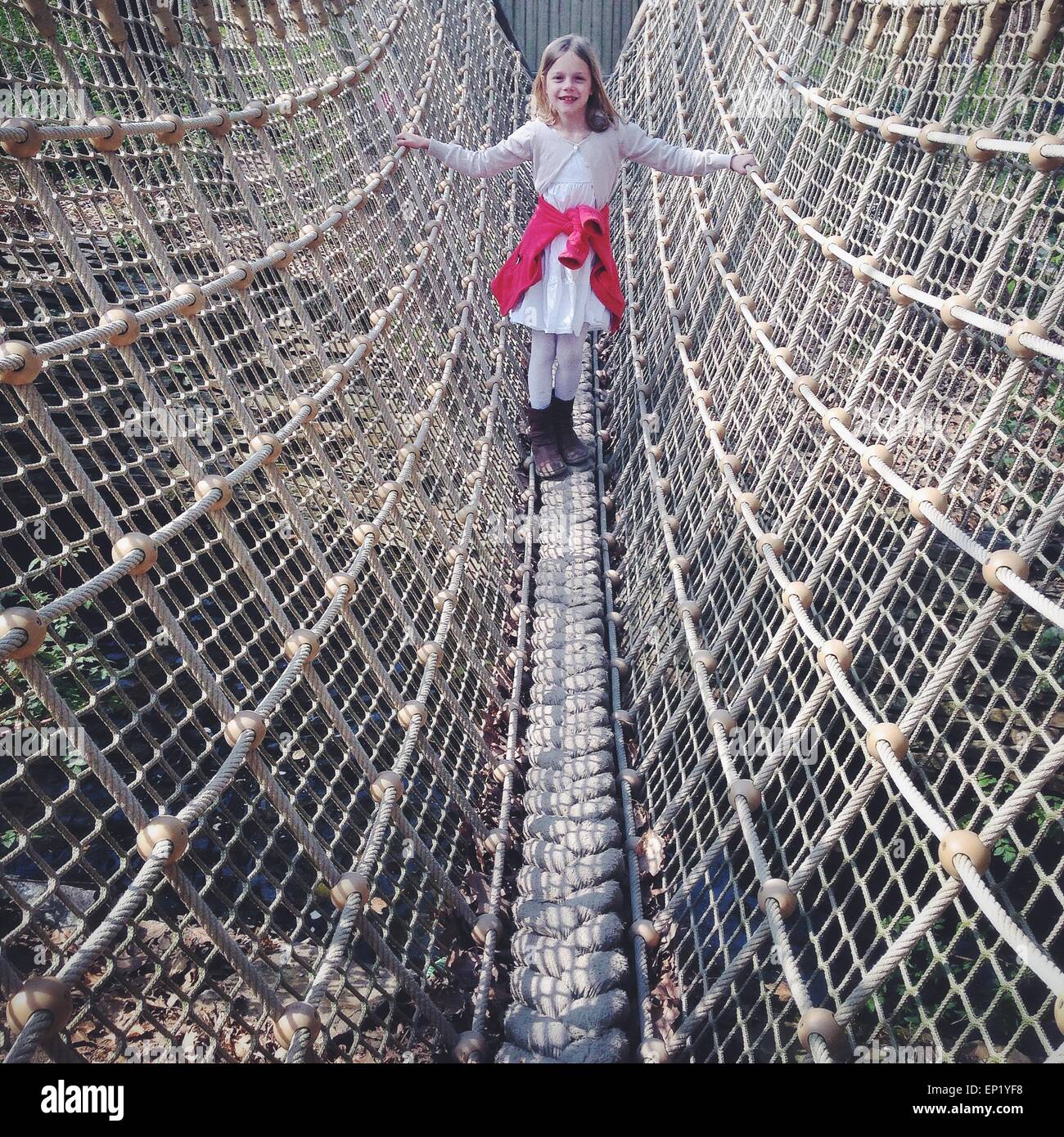 Fille debout sur un pont de corde Banque D'Images