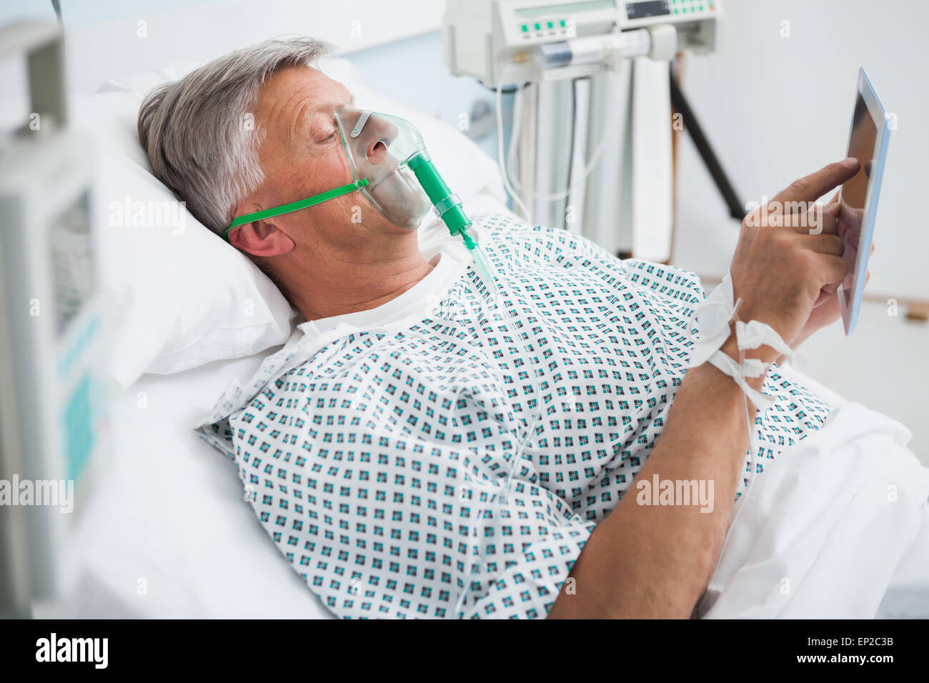Patient est allongé dans le lit de la lecture in hospital ward Banque D'Images