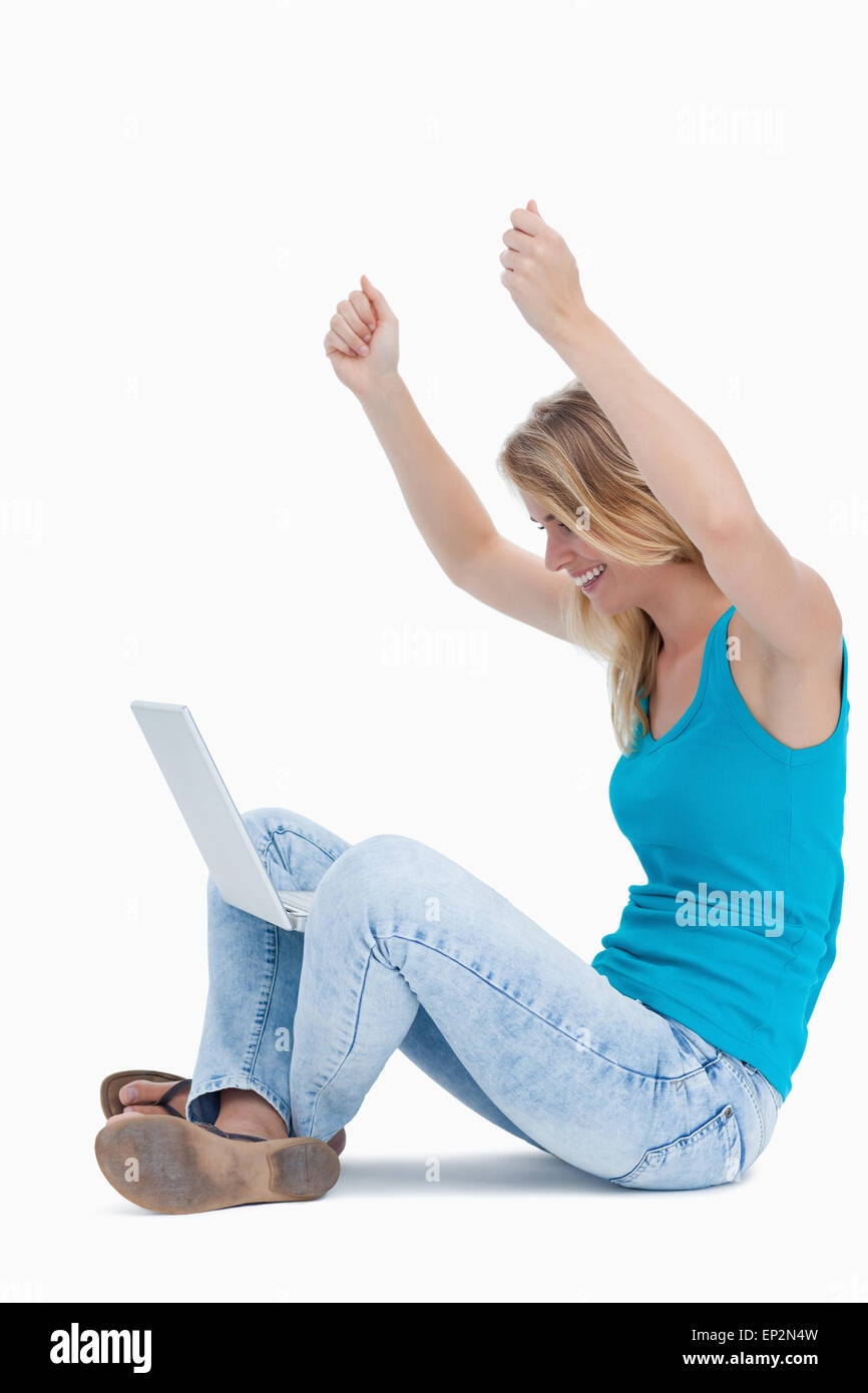 Une femme a son bras en l'air et un ordinateur portable entre ses jambes Banque D'Images Une femme a son bras en l'air et un ordinateur portable entre ses jambes Banque D'Images