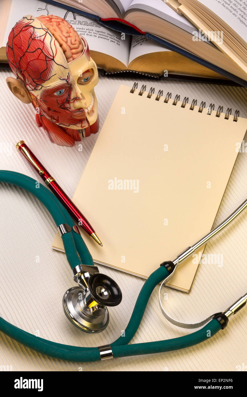 École de médecine - un bloc-notes et stylo avec un stéthoscope, étudiants en médecine, les manuels médicaux anatomie et modèle. Banque D'Images