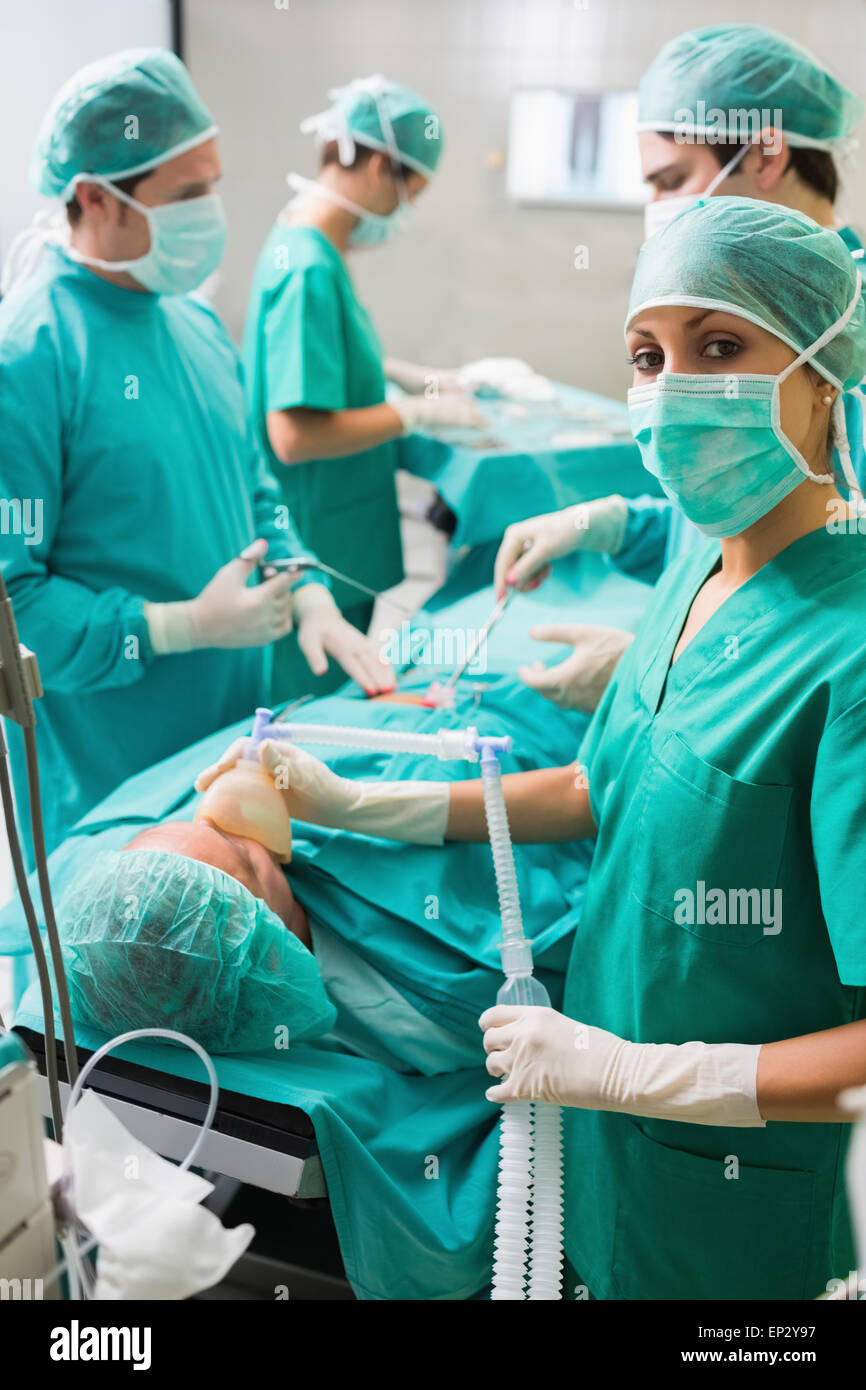 Nurse looking at camera tout en maintenant un masque à oxygène Banque D'Images