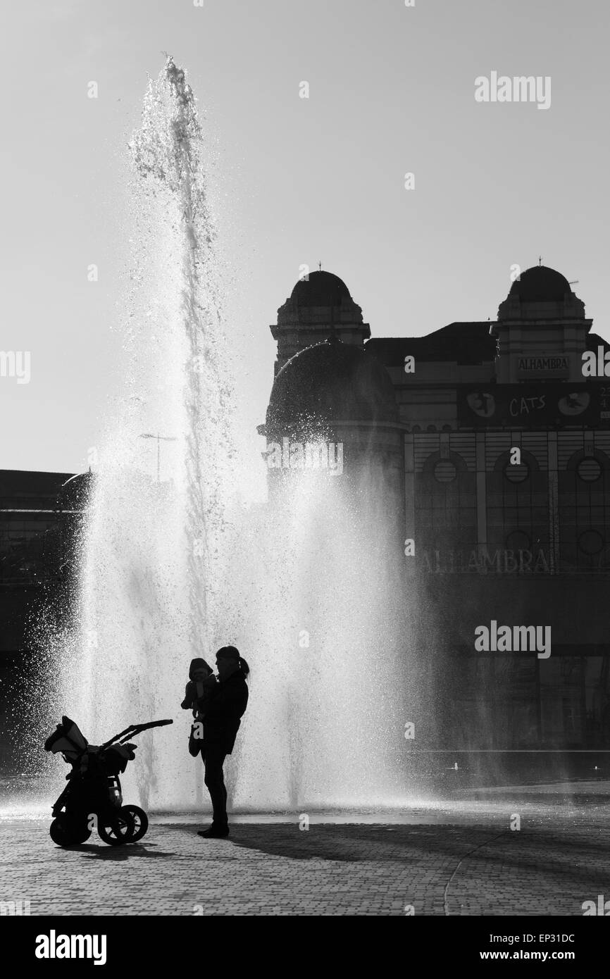 Une mère et son enfant découpé sur une fontaine à Bradford's City Park. Banque D'Images