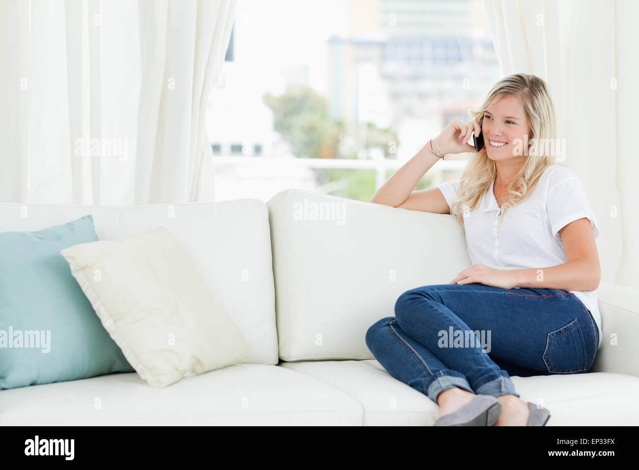 Une femme assise sur la table, comme elle parle sur son téléphone Banque D'Images Une femme assise sur la table, comme elle parle sur son téléphone Banque D'Images