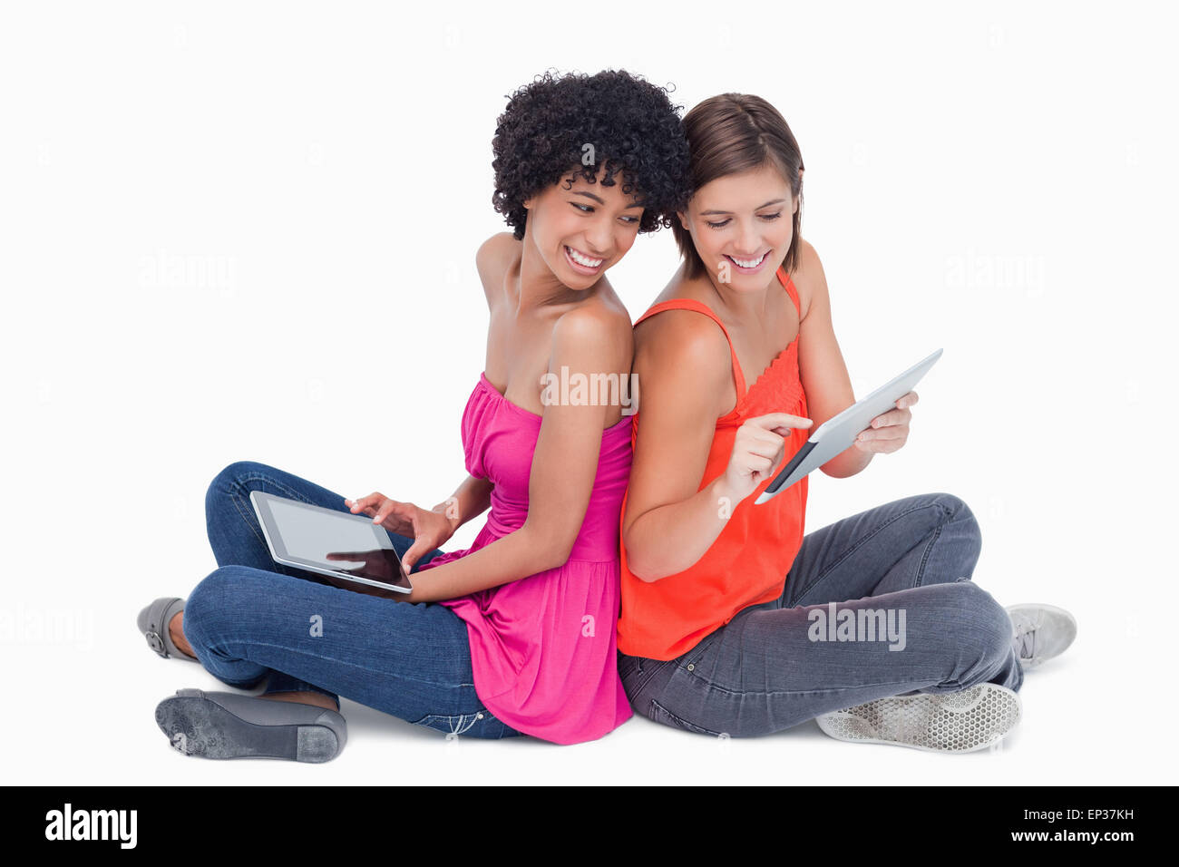 Smiling teenage, fiers de présenter sa tablette PC à son amie Banque D'Images Smiling teenage, fiers de présenter sa tablette PC à son amie Banque D'Images