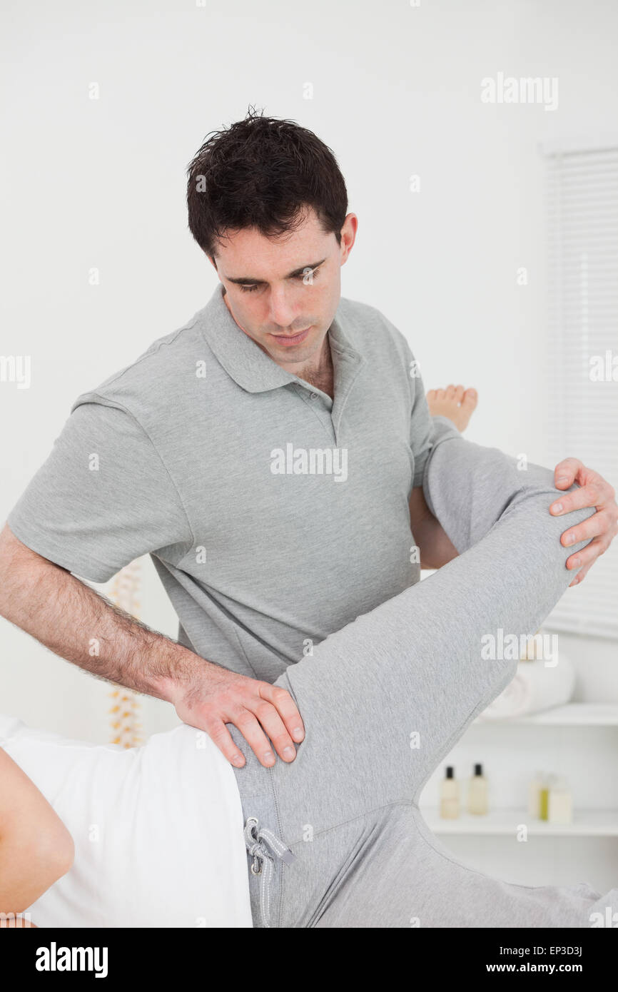 Physiothérapeute debout derrière une femme tout en étirant la jambe Banque D'Images