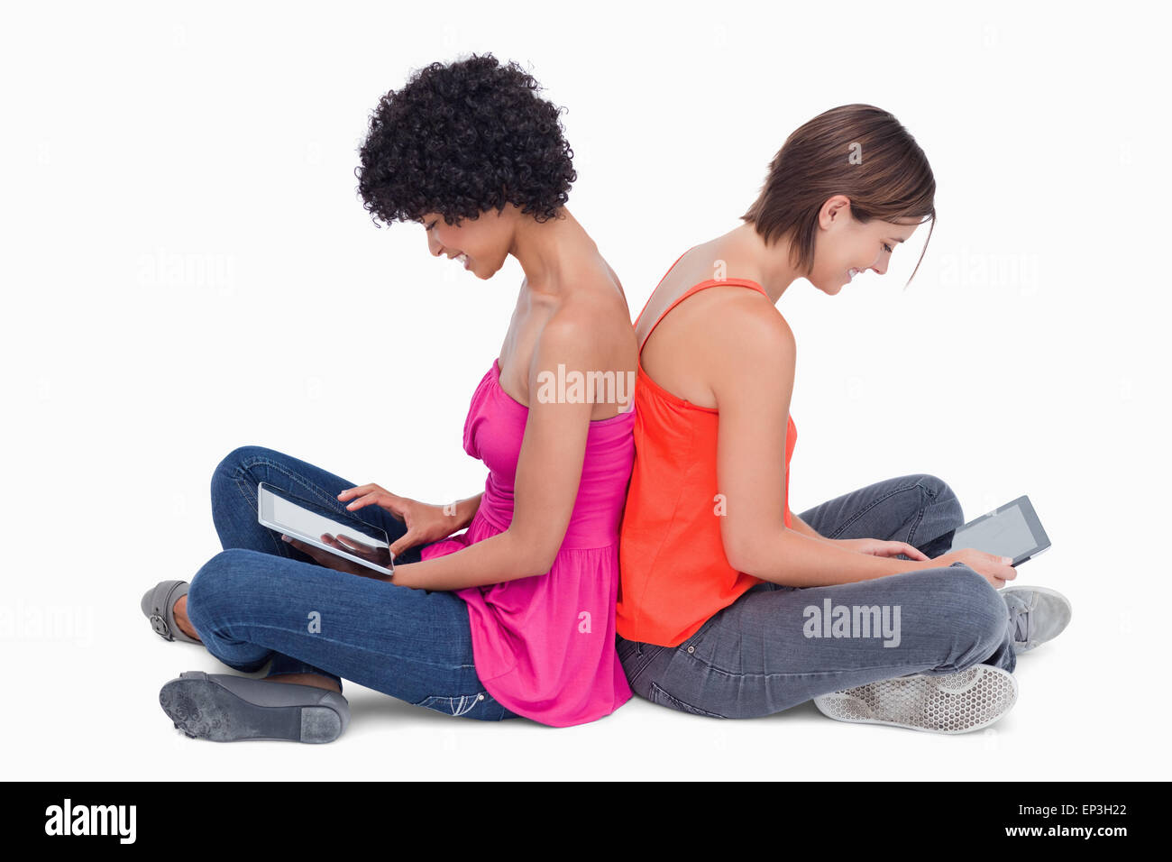 Les adolescents assis en tailleur dos à dos avec un ordinateur tablette Banque D'Images Les adolescents assis en tailleur dos à dos avec un ordinateur tablette Banque D'Images