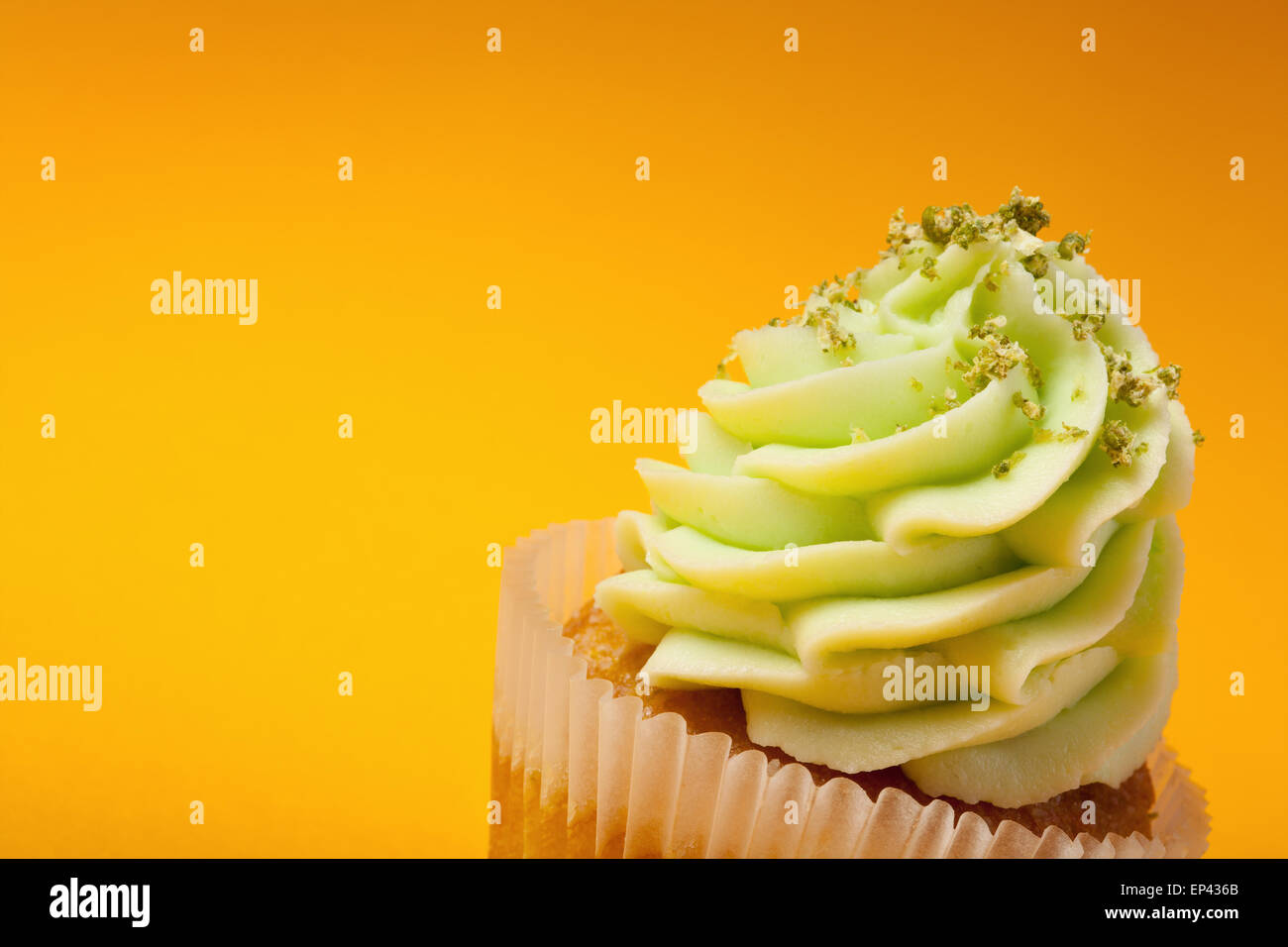 Avec crème cupcake isolé sur fond orange Banque D'Images