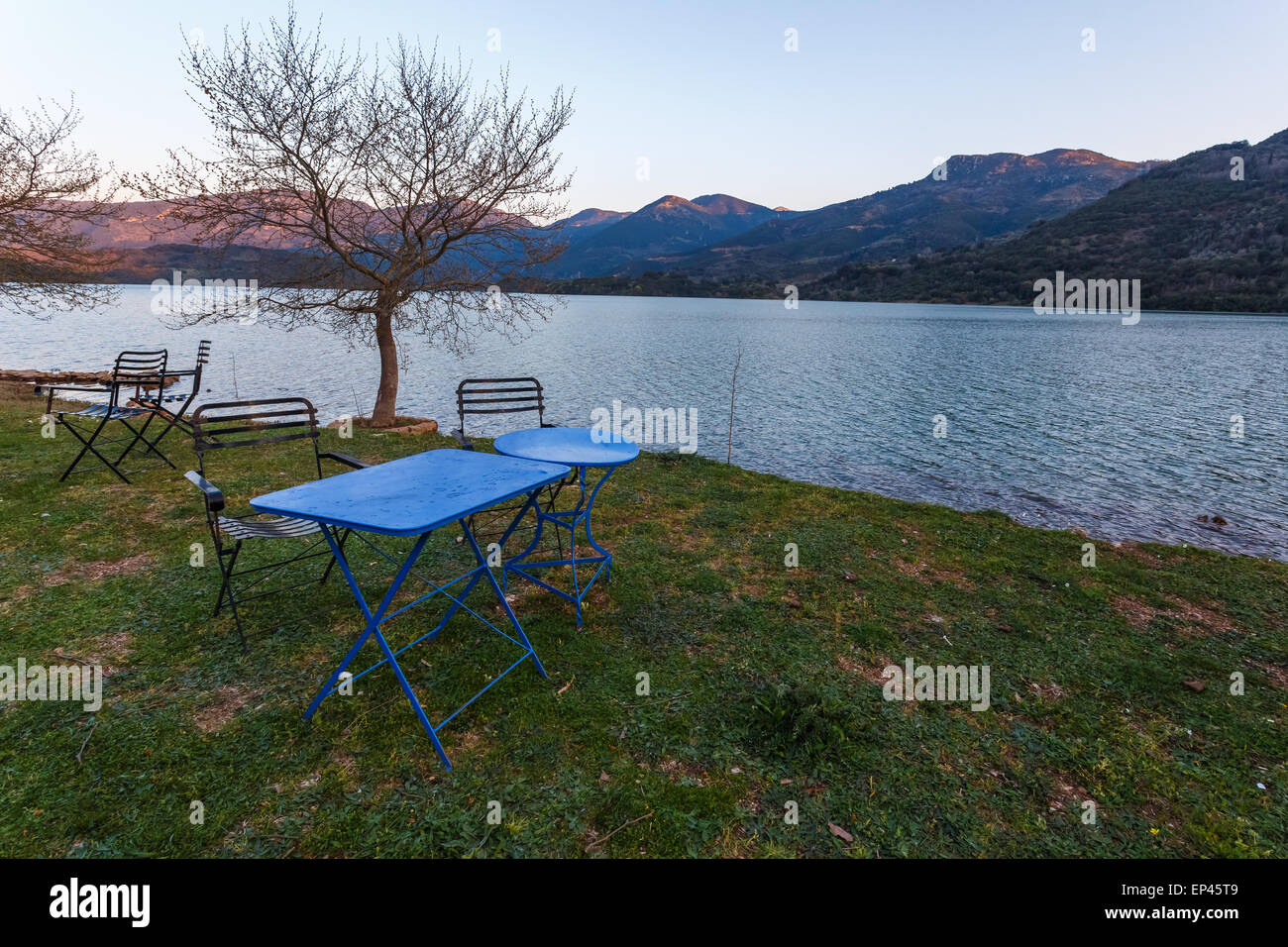 Vintage fer à repasser table et chaises en face de Ladonas Lake, la Grèce l'après-midi Banque D'Images