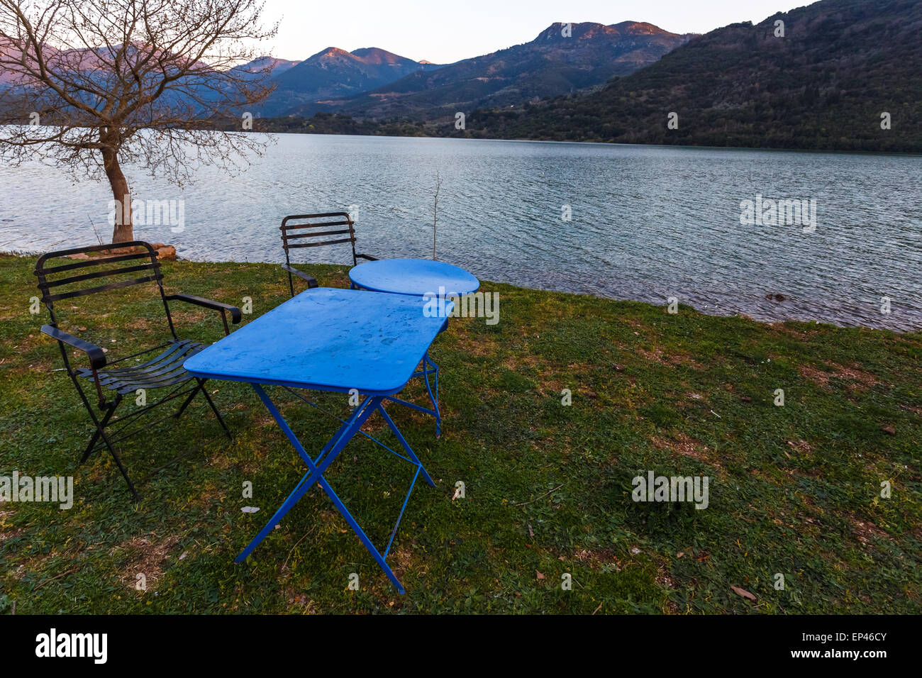 Vintage fer à repasser table et chaises en face de Ladonas Lake, la Grèce l'après-midi Banque D'Images