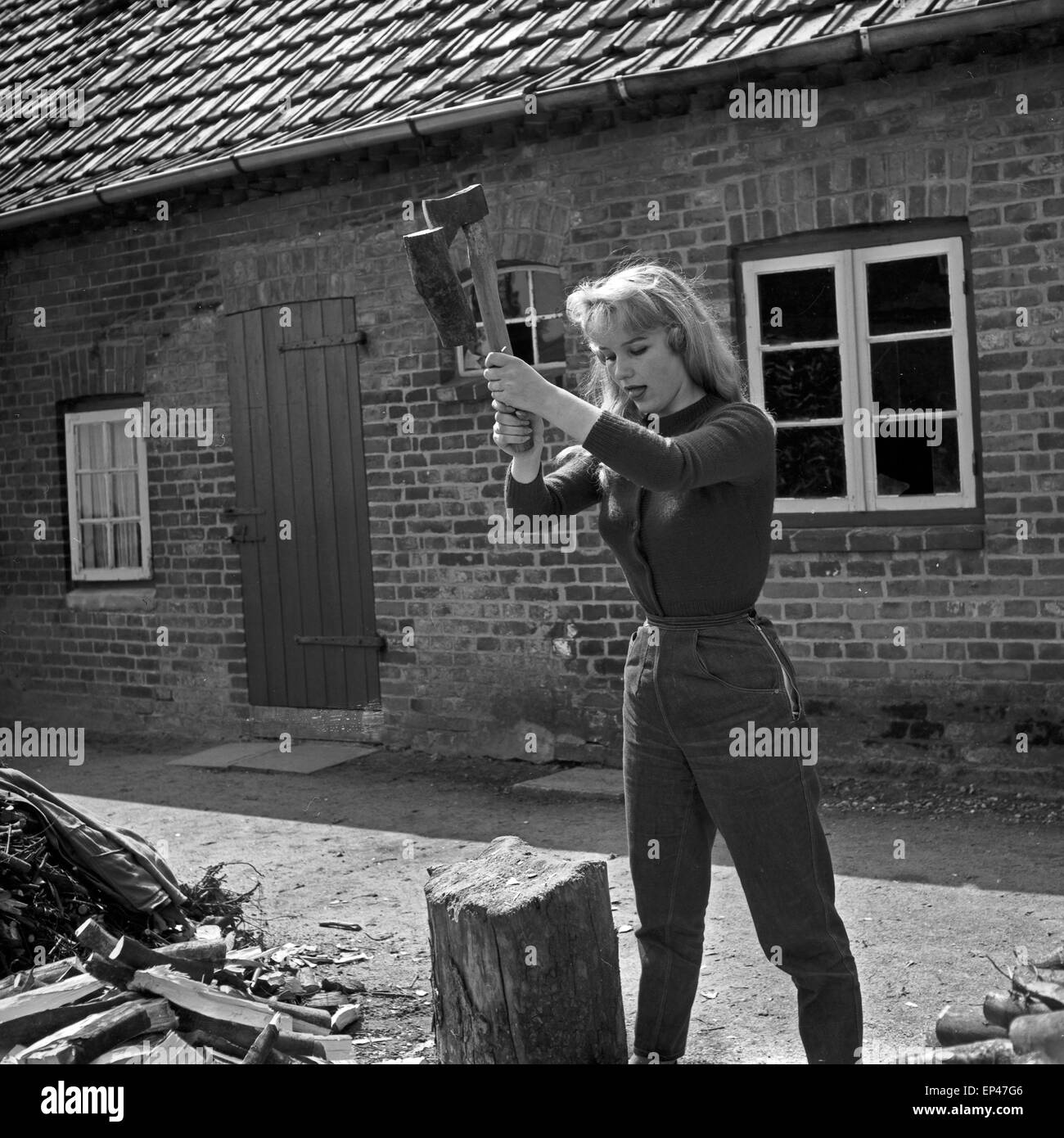 Deutsche Schauspielerin Karin Stoltenfeldt Holzhacken Haus, Deutschland 1950er Jahre. L'actrice allemande Karin puce Stoltenfeldt Banque D'Images