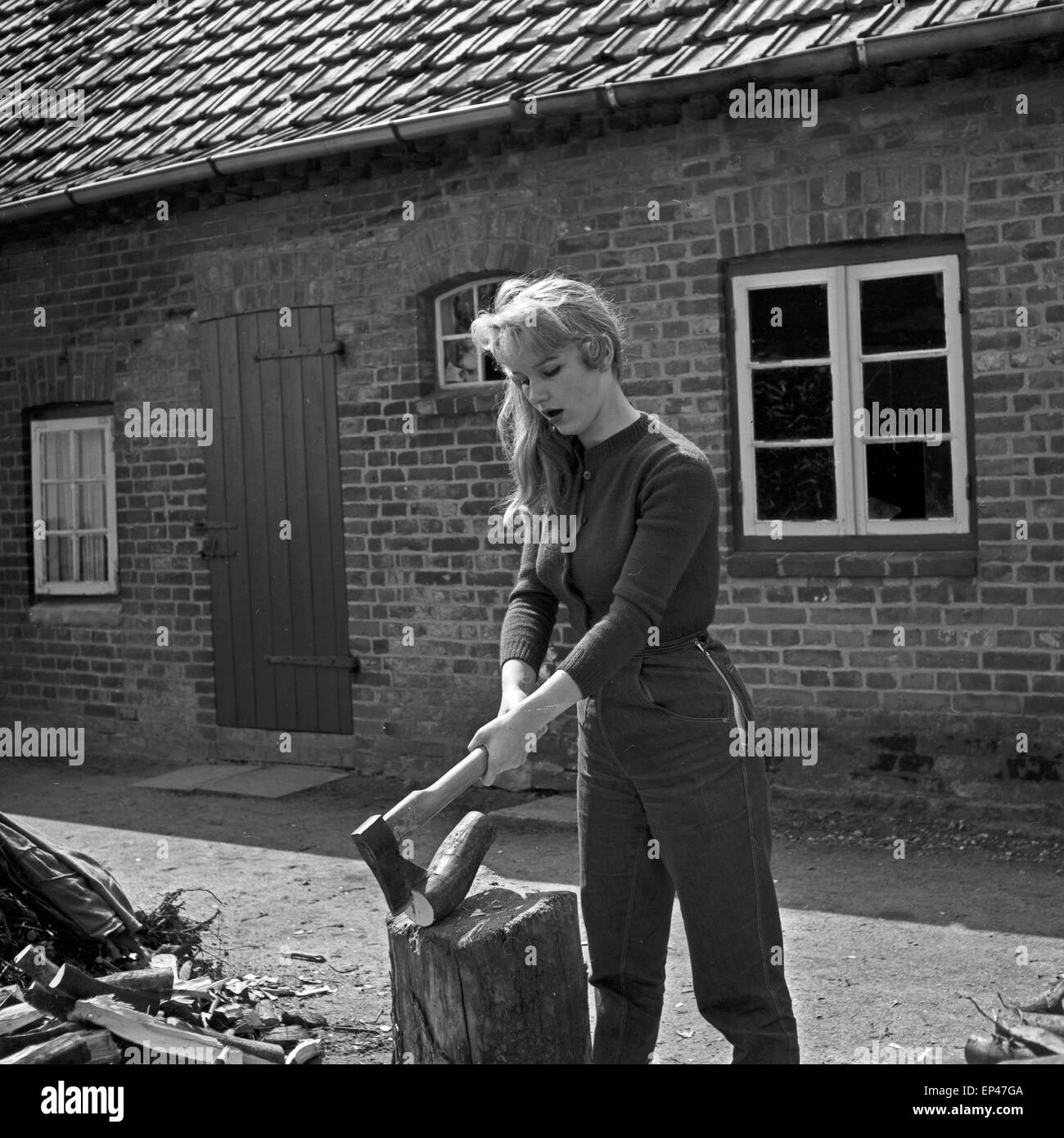 Deutsche Schauspielerin Karin Stoltenfeldt Holzhacken Haus, Deutschland 1950er Jahre. L'actrice allemande Karin puce Stoltenfeldt Banque D'Images