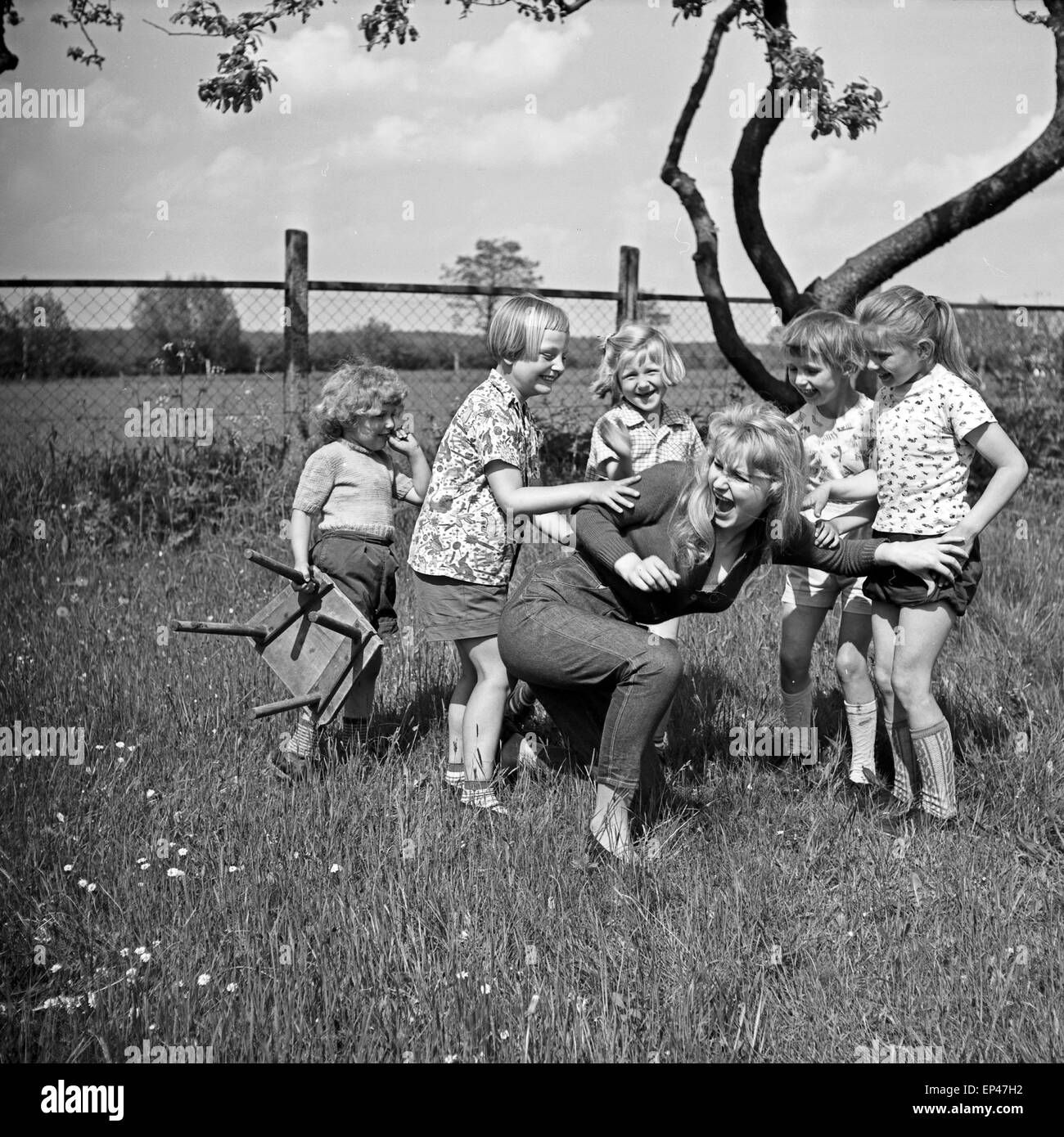 Deutsche Schauspielerin Karin Stoltenfeldt spielt mit Kindern im Garten, Deutschland 1950er Jahre. L'actrice allemande Karin Stol Banque D'Images