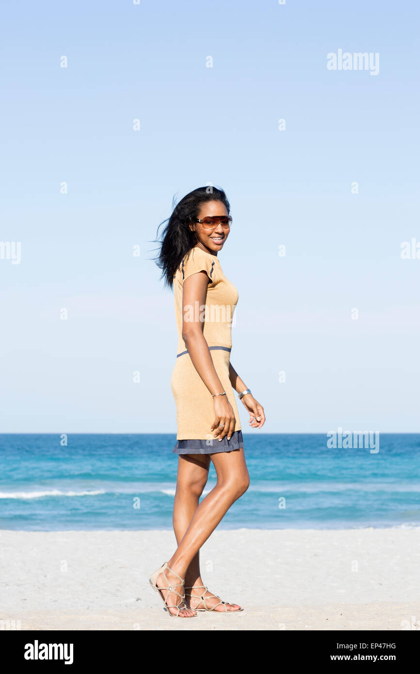 Jeune femme élégante marchant le long de la plage Banque D'Images
