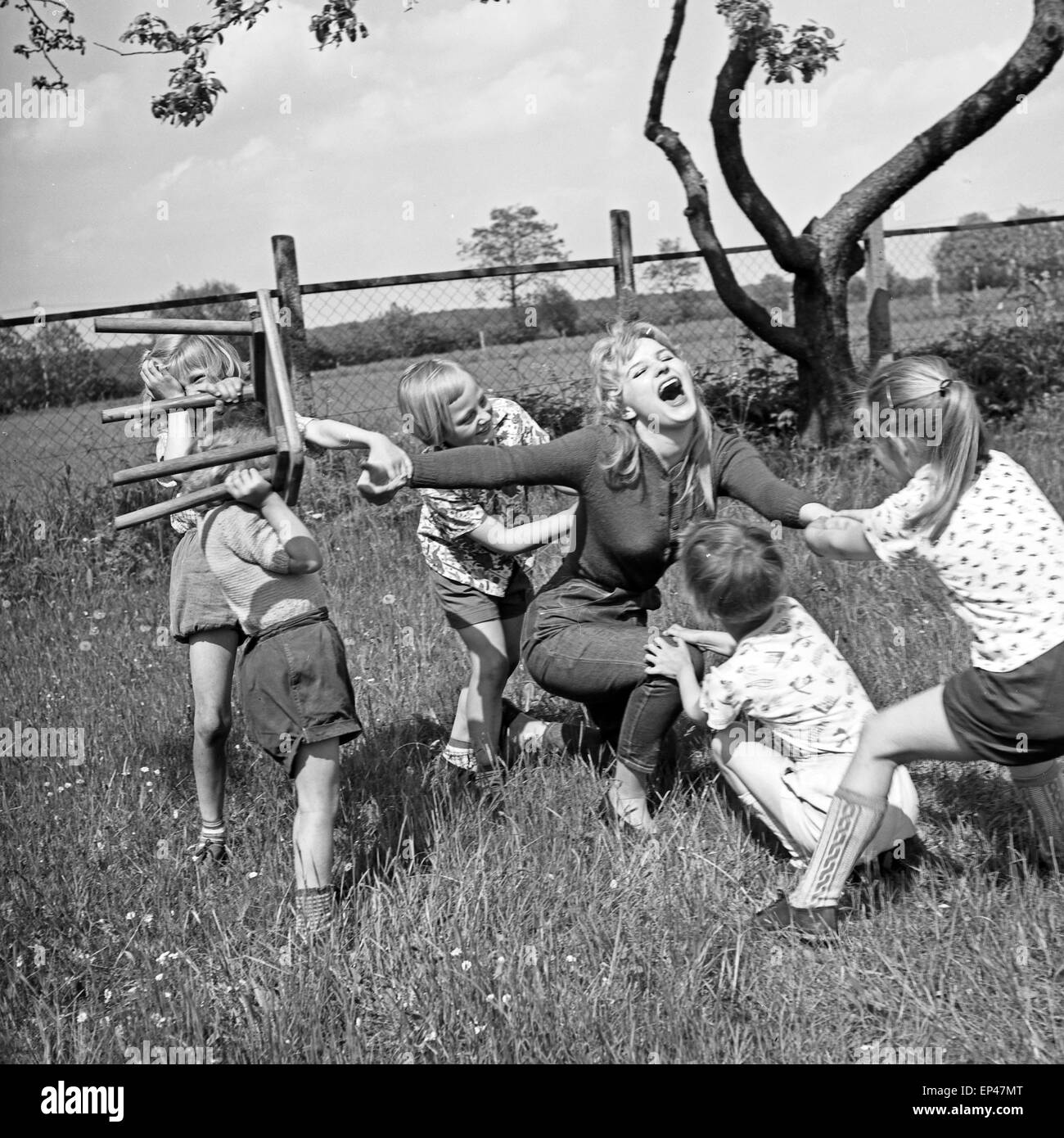 Deutsche Schauspielerin Karin Stoltenfeldt spielt mit Kindern im Garten, Deutschland 1950er Jahre. L'actrice allemande Karin Stol Banque D'Images