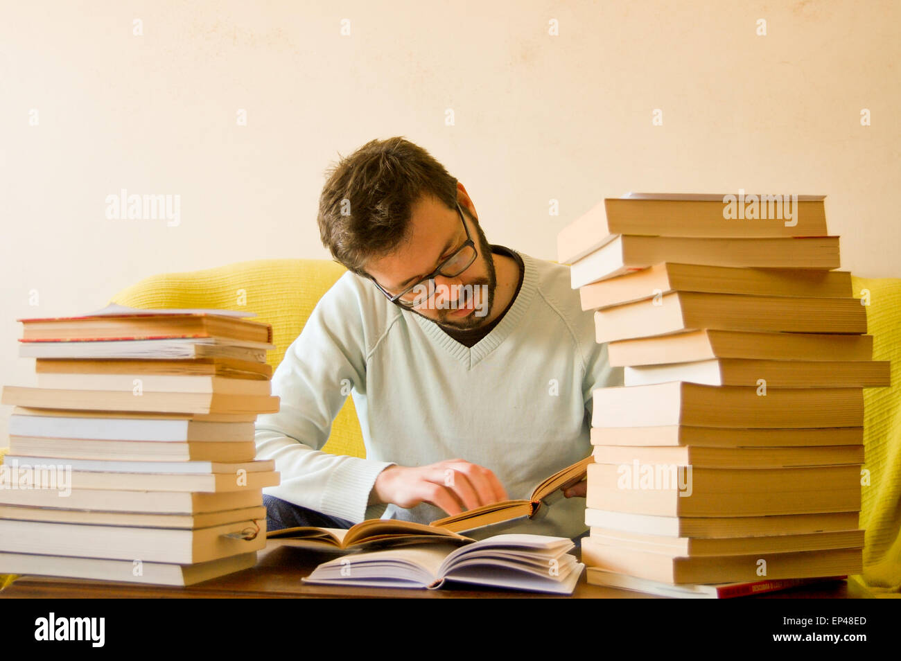 L'étude de l'homme avec une pile de livres en face de lui Banque D'Images