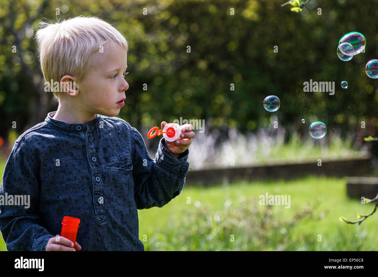 main d'enfant tenant une baguette pour souffler des bulles de savon contre  le ciel bleu lors d'une journée d'été ensoleillée. 11032614 Photo de stock  chez Vecteezy