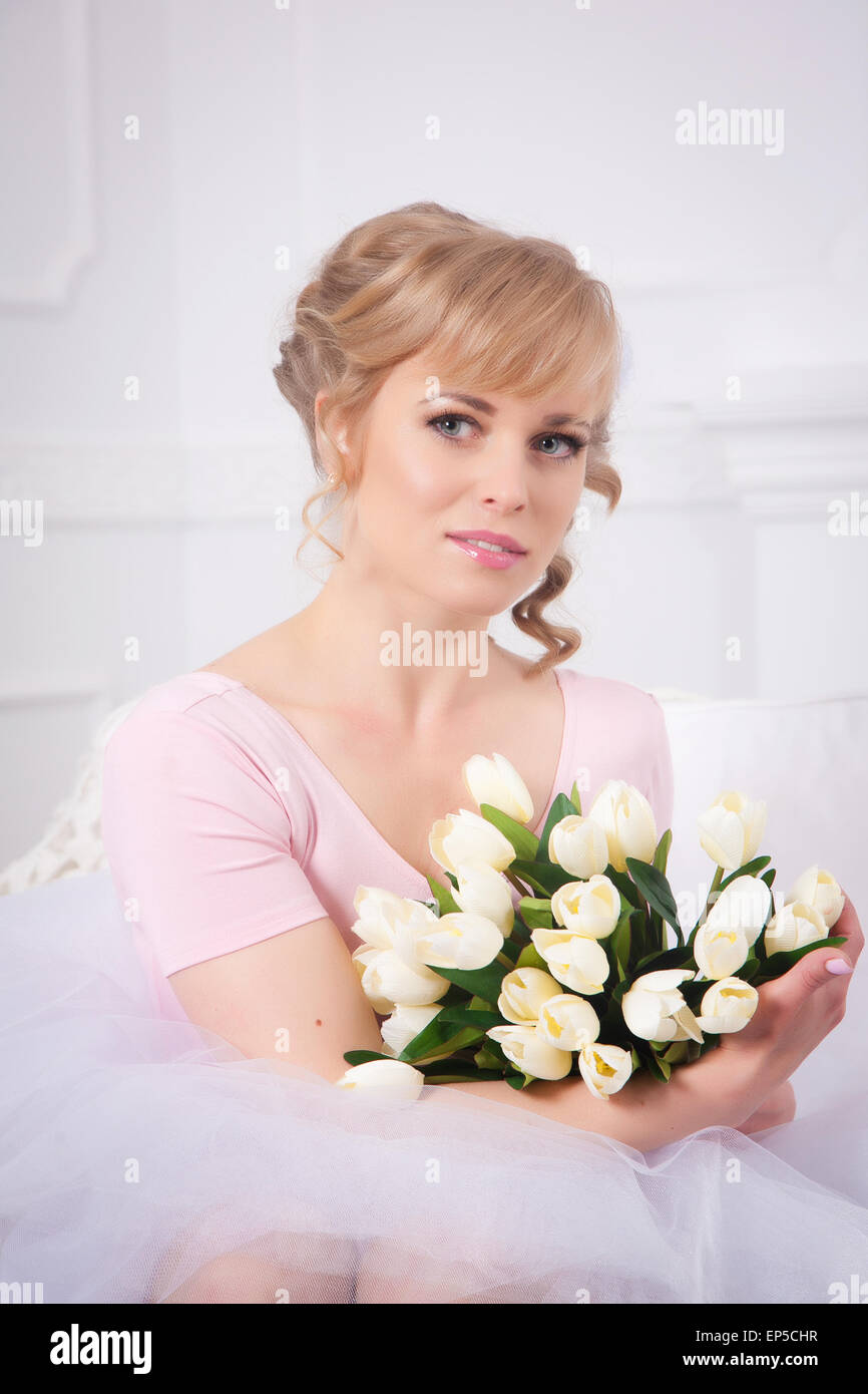 Portrait d'une belle blonde femme avec un bouquet de tulipes Banque D'Images
