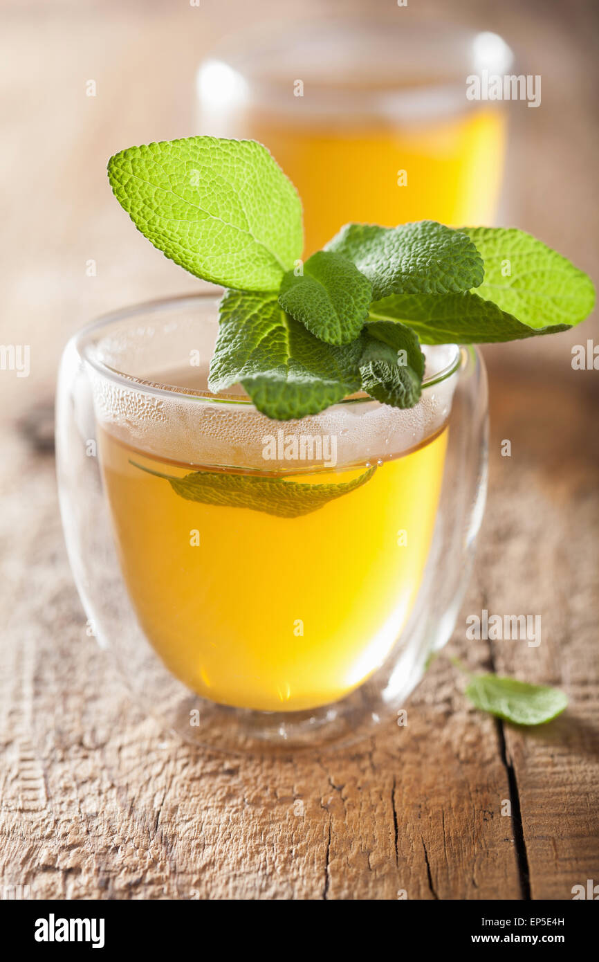 Sage de fines herbes avec du thé vert feuille dans verre tasse Banque D'Images