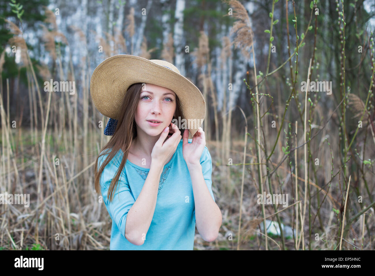 Fille de rousseur dans hat looking at camera au printemps Banque D'Images