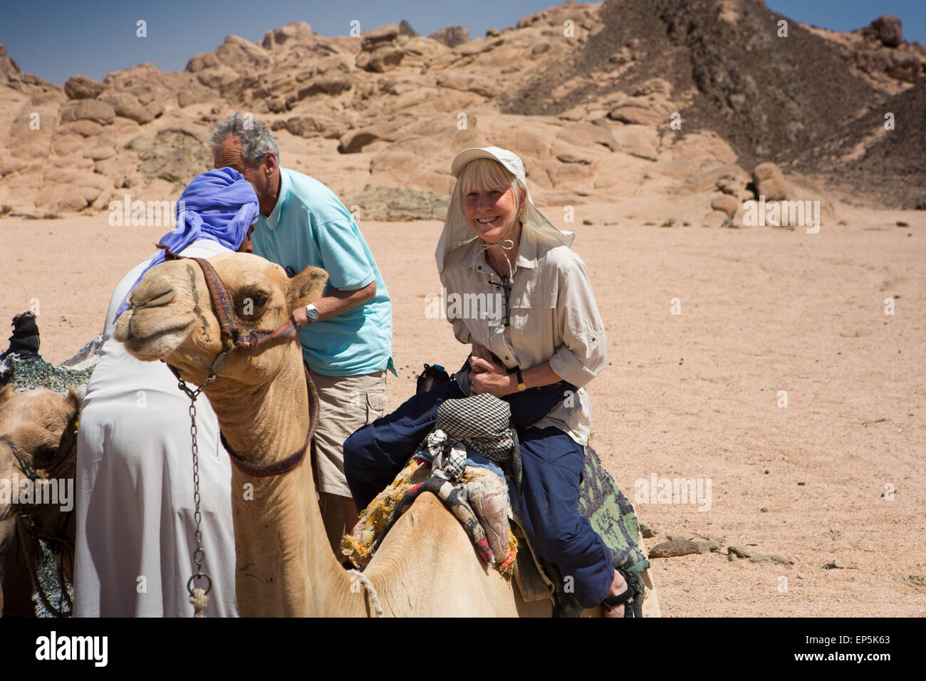 L'Egypte, le Sinaï, Sharm el Sheikh, le Parc National de Nabq, senor touriste sur chameau bédouin pour desert ride Banque D'Images