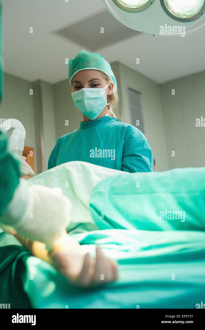 Regarder le stagiaire tout en maintenant la chirurgie d'un masque à oxygène Banque D'Images