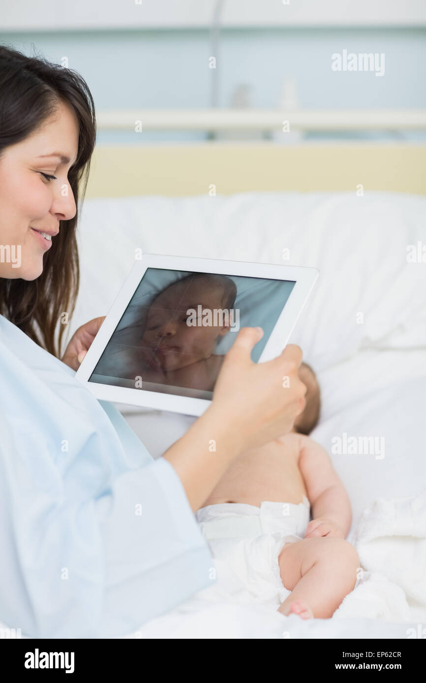 Heureuse fête à l'aide d'un comprimé pour prendre une photo d'un bébé nouveau-né Banque D'Images Heureuse fête à l'aide d'un comprimé pour prendre une photo d'un bébé nouveau-né Banque D'Images