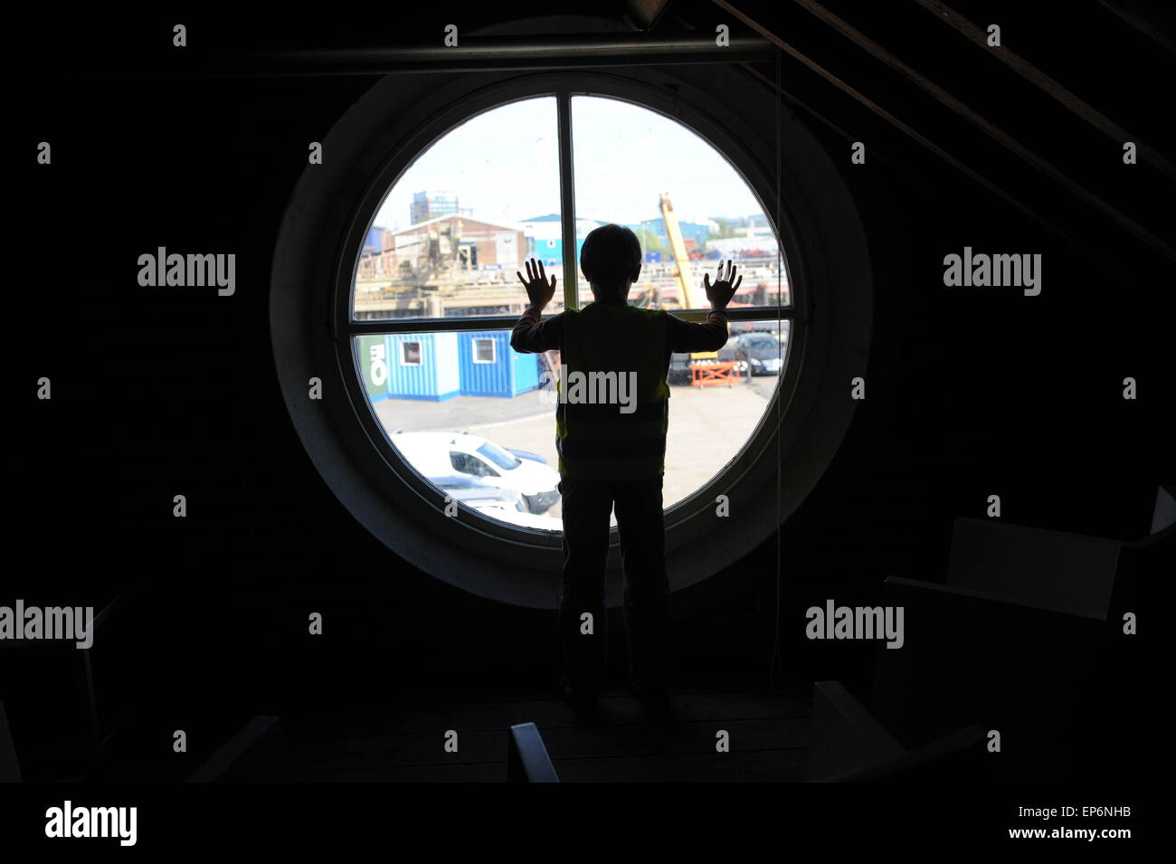 10 ans garçon anglais regardant par la fenêtre du phare dans Trinity Buoy Wharf phare. Banque D'Images