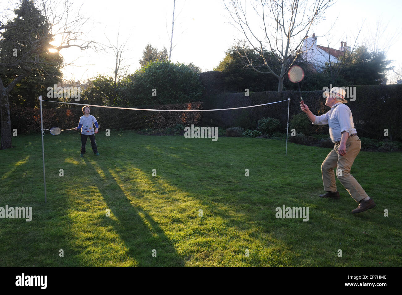 Grand-père et petit-fils jouer au badminton ensemble dans le jardin en Ile-de-France France Banque D'Images
