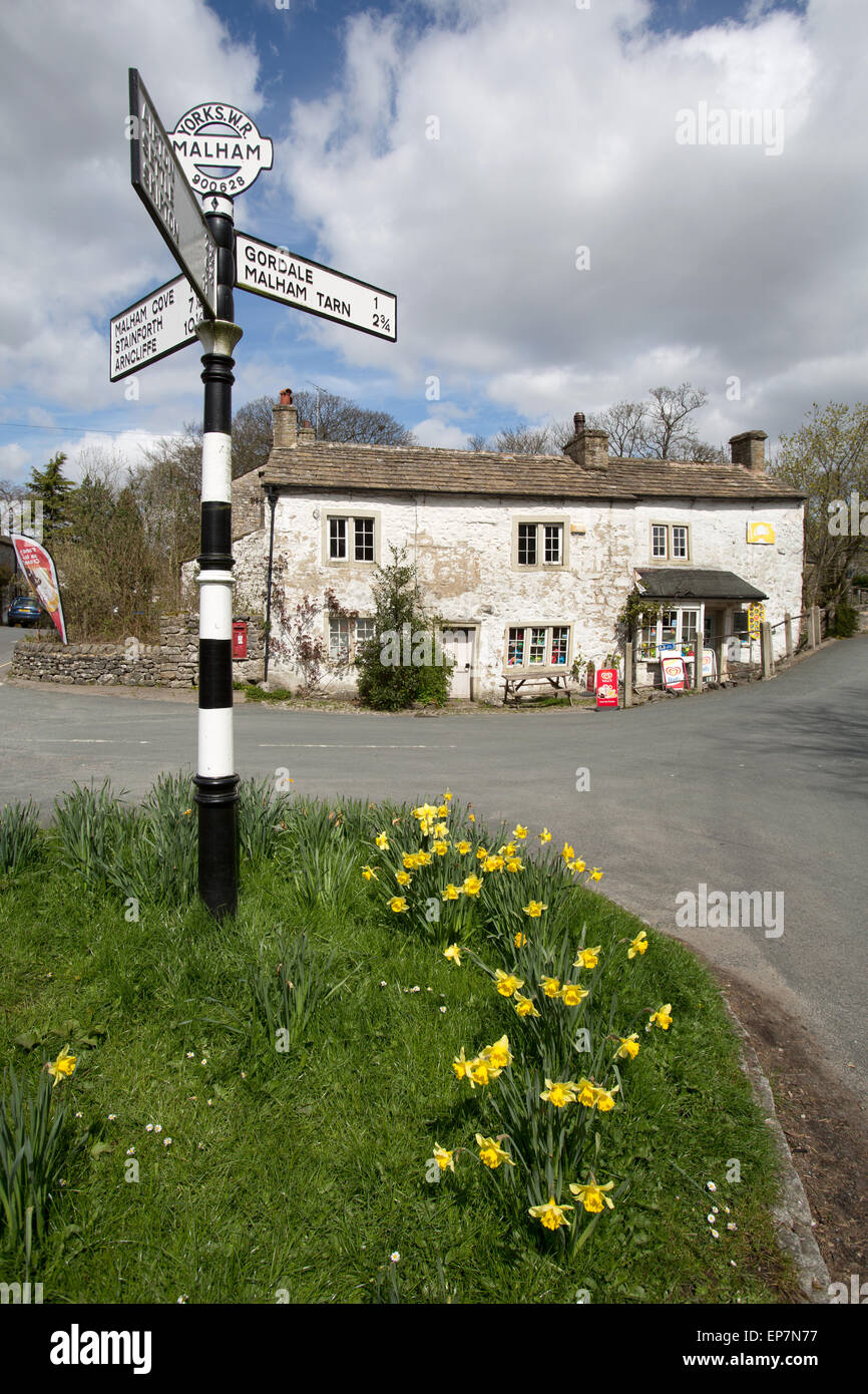 Village de Malham, Yorkshire, Angleterre. Printemps pittoresque vue sur une route en direction de pré Worboys sign in Malham. Banque D'Images
