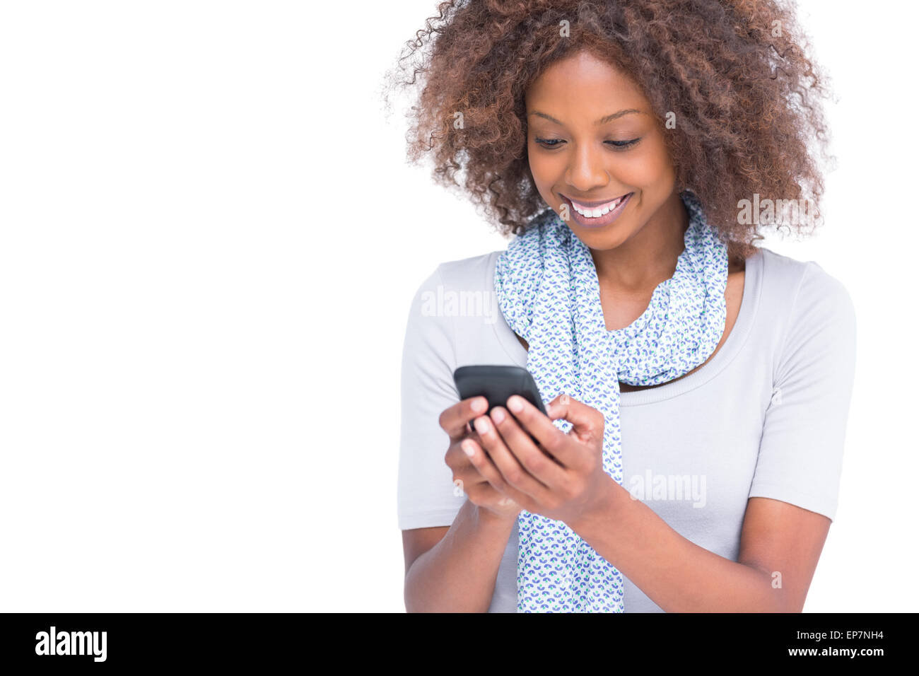 Cheerful woman de la saisie d'un message texte sur son smartphone Banque D'Images