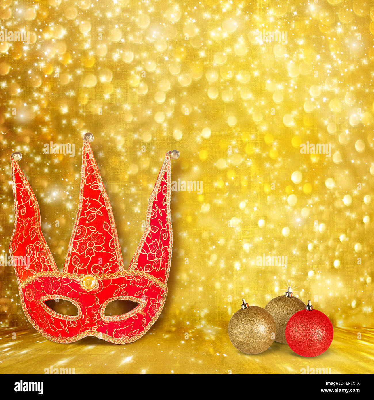 Masque de carnaval et une boule de Noël rouge sur un fond doré avec effet bokeh Banque D'Images