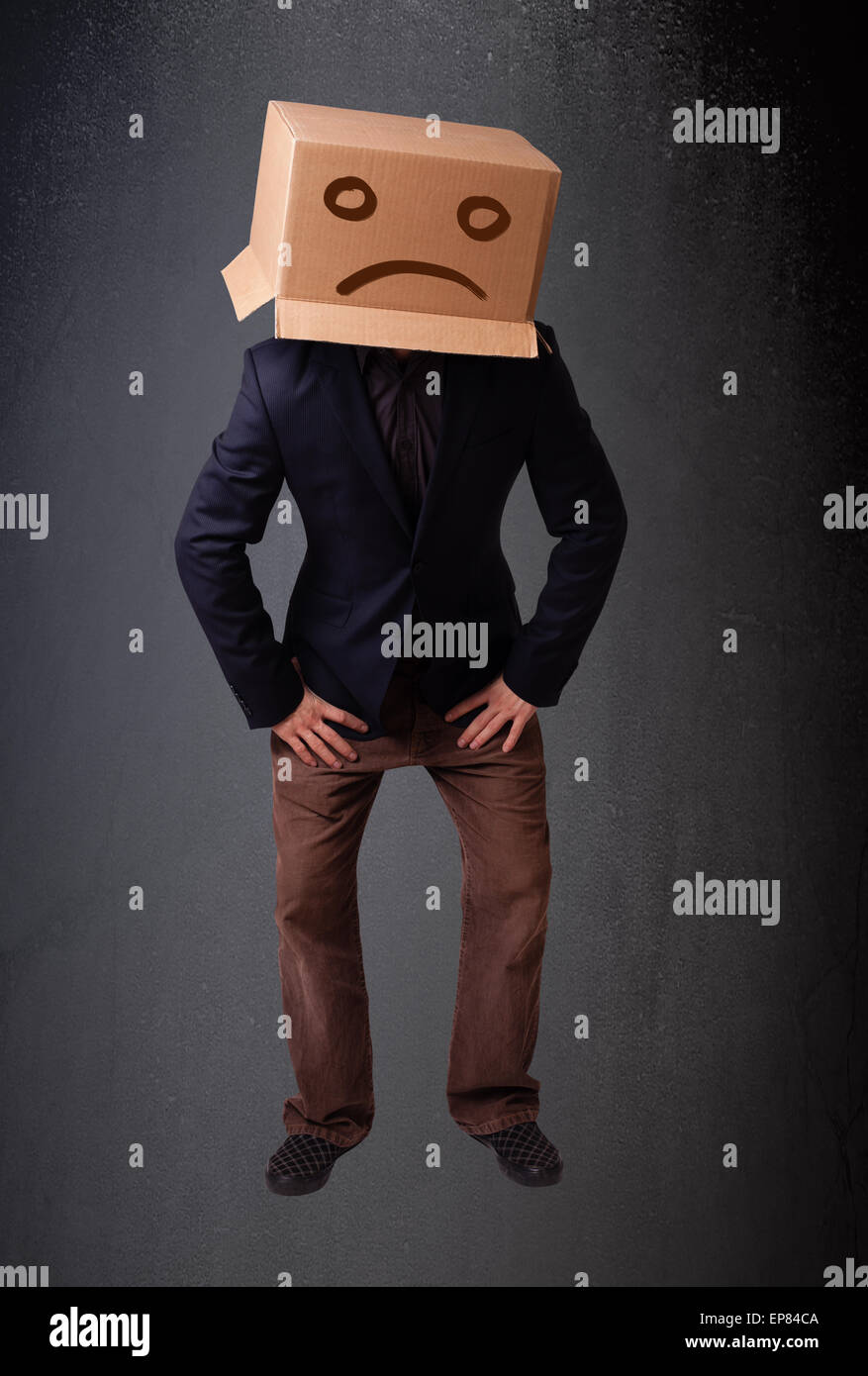 Jeune homme brun avec une boîte en carton sur la tête avec visage triste Banque D'Images