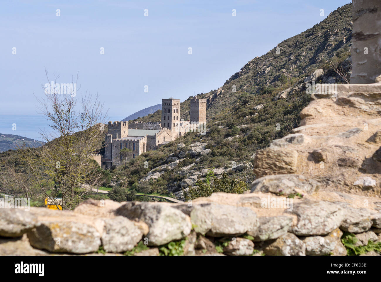 Ancien monastère entouré par un mur de pierre. Sant Pere de Rodes encadrée par mur de la mur qui entoure l'église Sta Helena. Banque D'Images