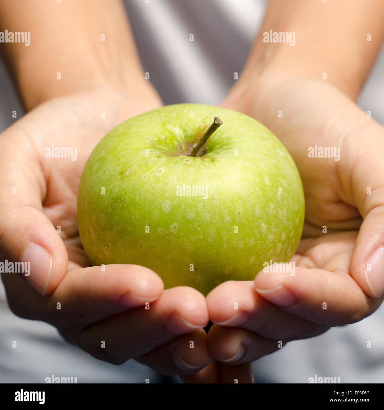 Woman hand holding fruit pomme verte Banque D'Images
