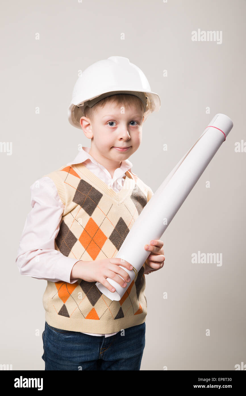 Garçon dans un casque de construction blanc tenant un dessin Banque D'Images
