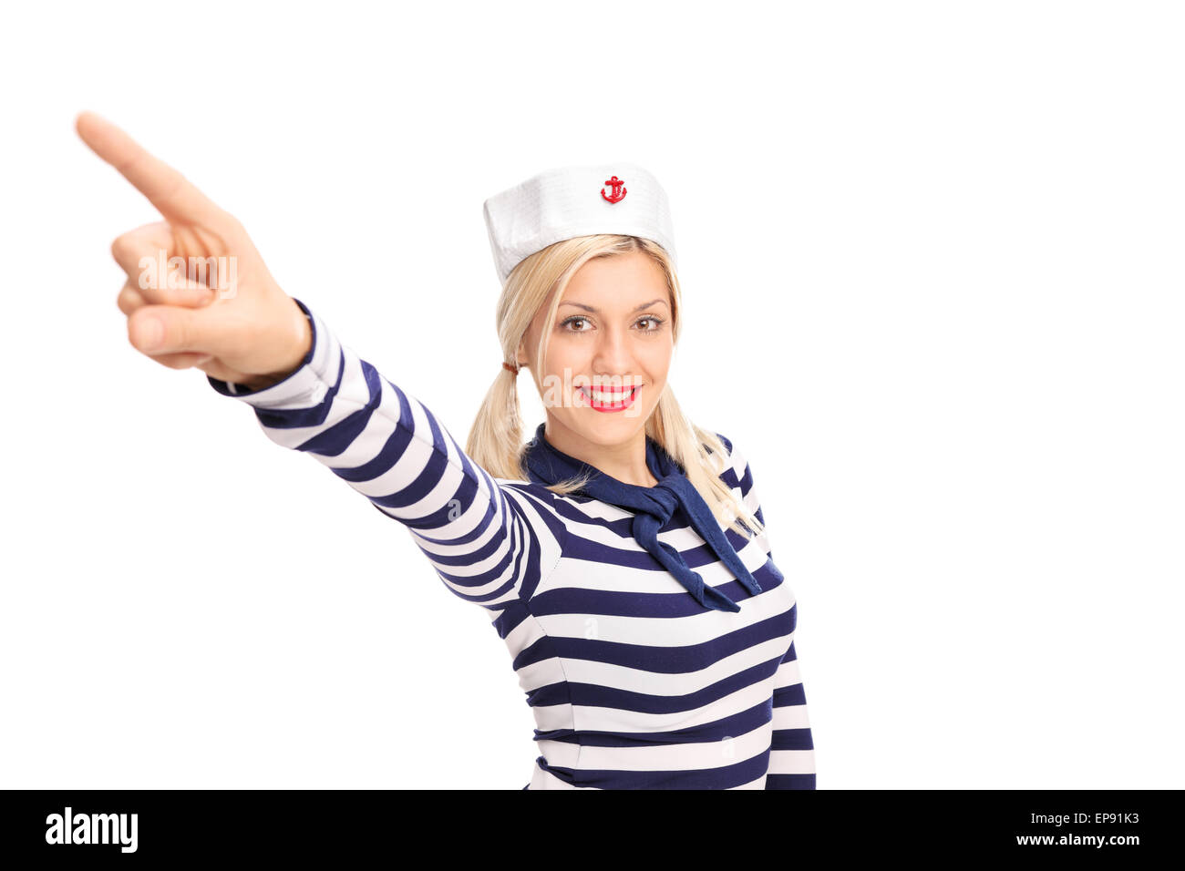 Beau marin femmes avec un chapeau de marin et une chemise rayée pointant vers le haut avec son doigt et souriant Banque D'Images