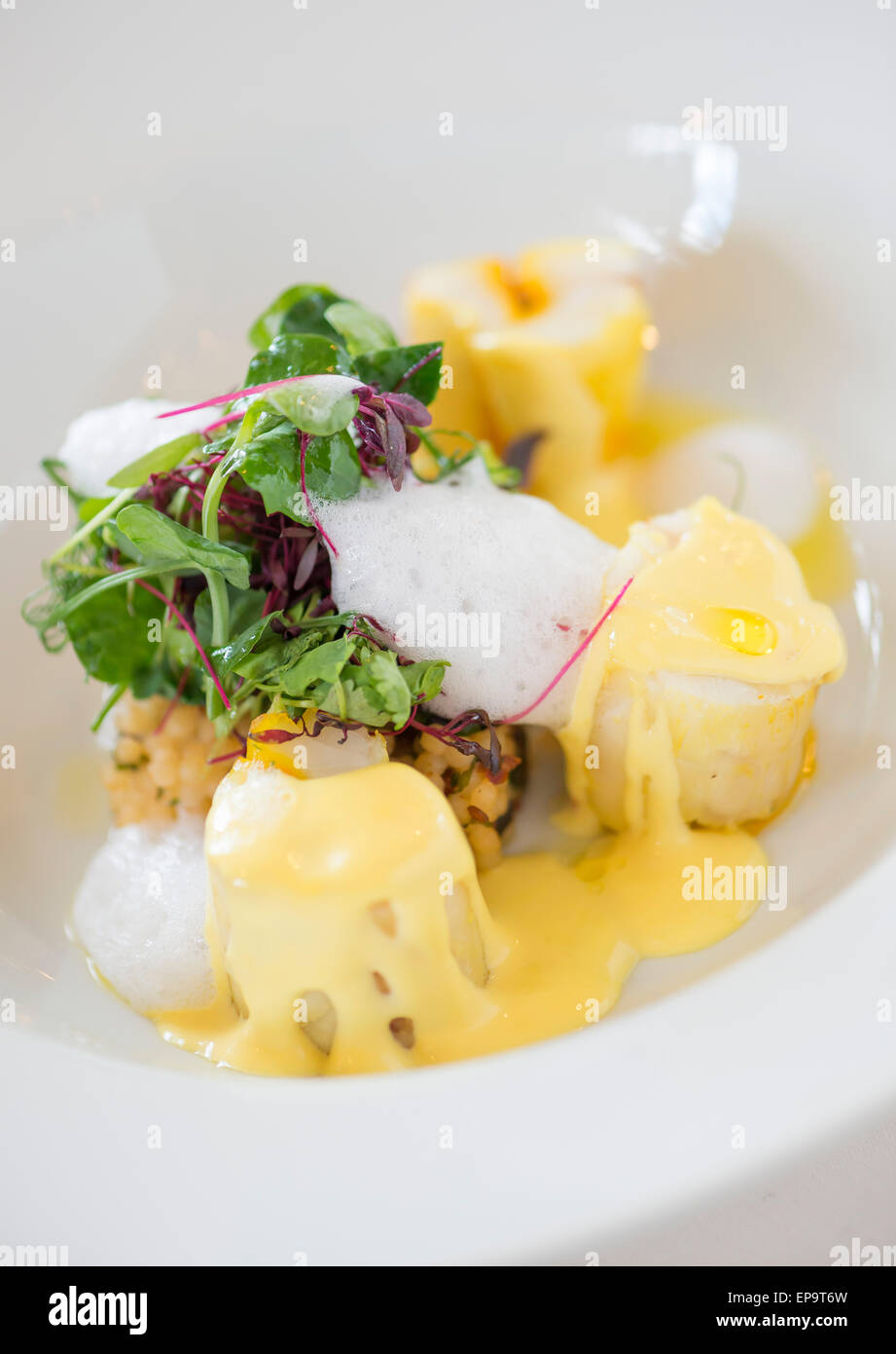 Coriandre et safran lotte infusée, couscous, olives noires et citron mousse. Banque D'Images