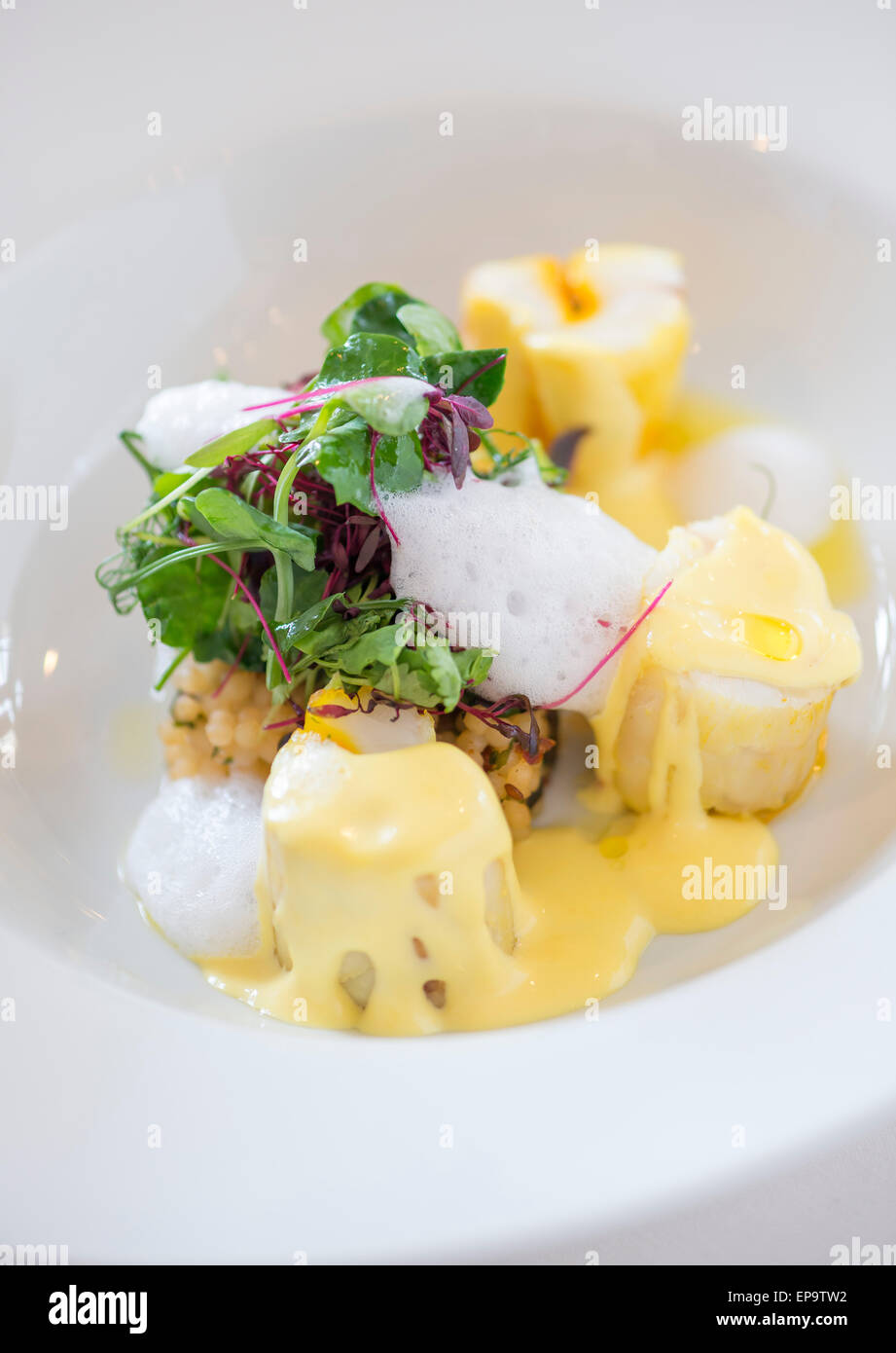 Coriandre et safran lotte infusée, couscous, olives noires et citron mousse. Banque D'Images