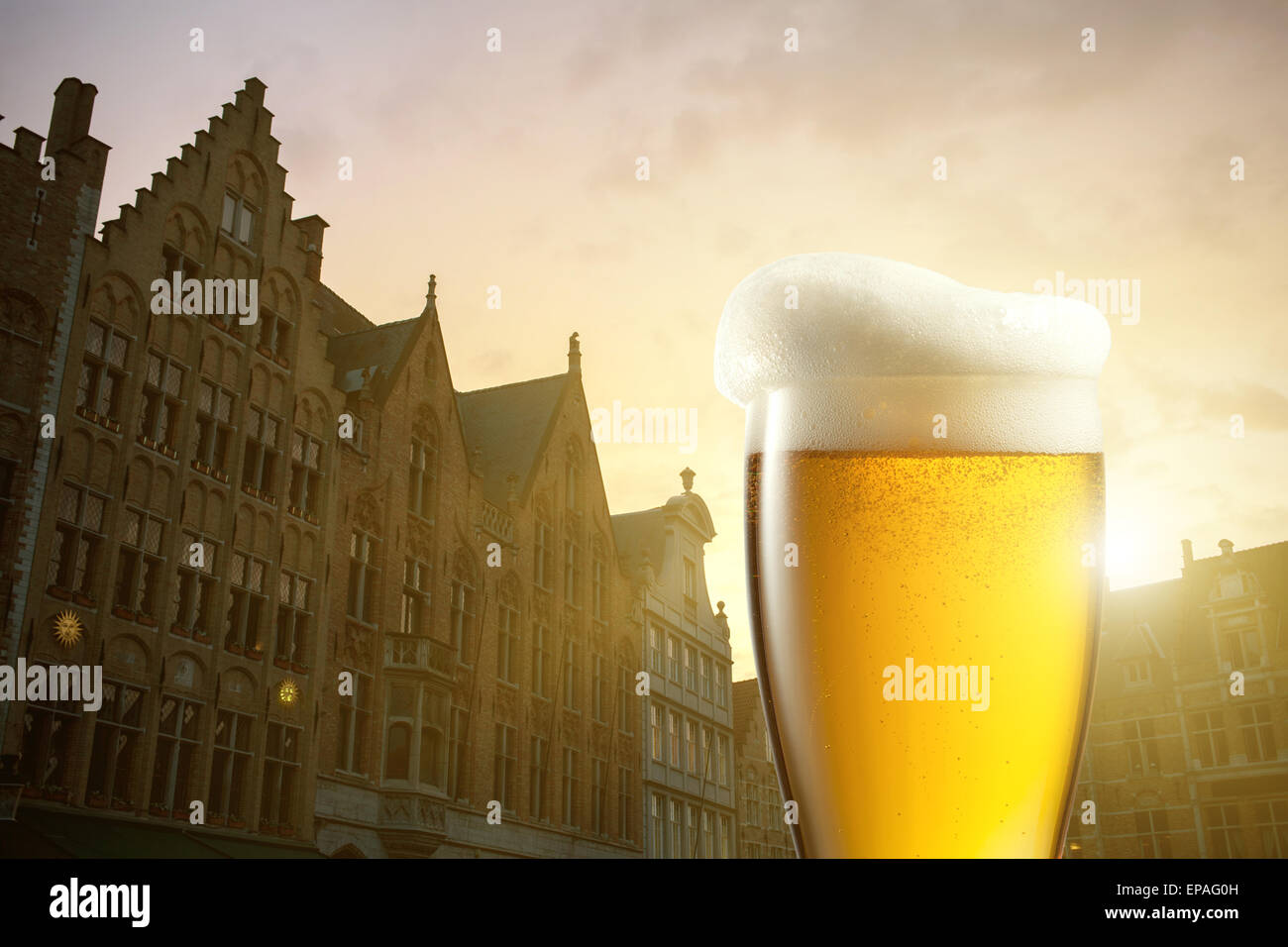 Verre de bière contre les silhouettes de maisons à Bruges, Belgique Banque D'Images